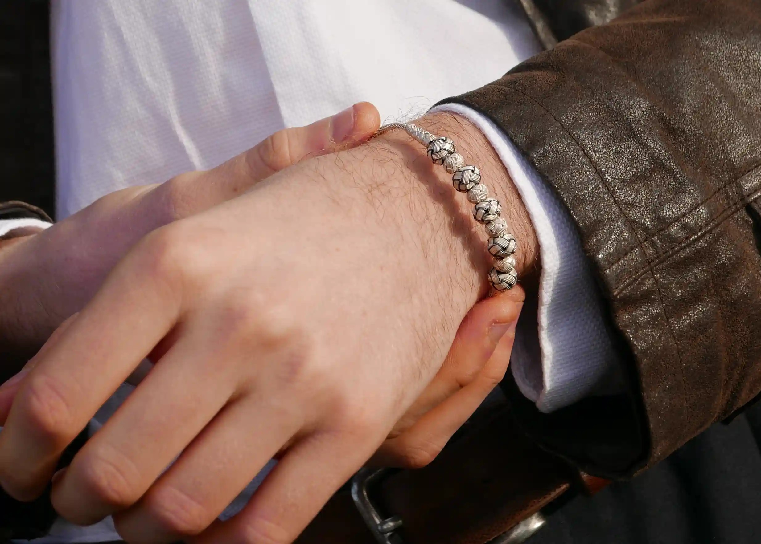 Silver bracelet from the Kokaz jewellery collection, 5 white knots, worn by a man