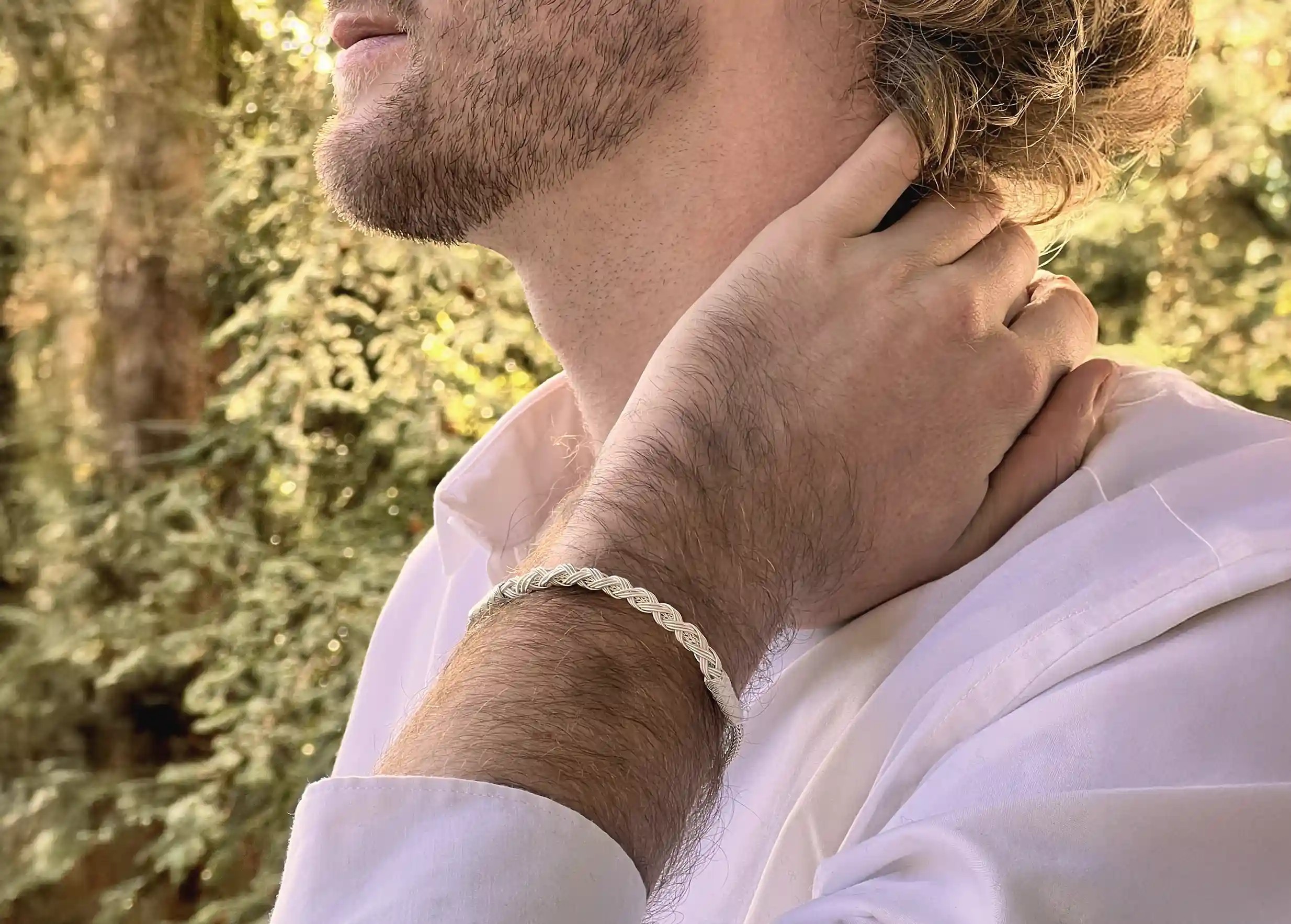 Man gazing at the horizon, wearing a silver braid bracelet from the Kokaz jewellery collection on his wrist