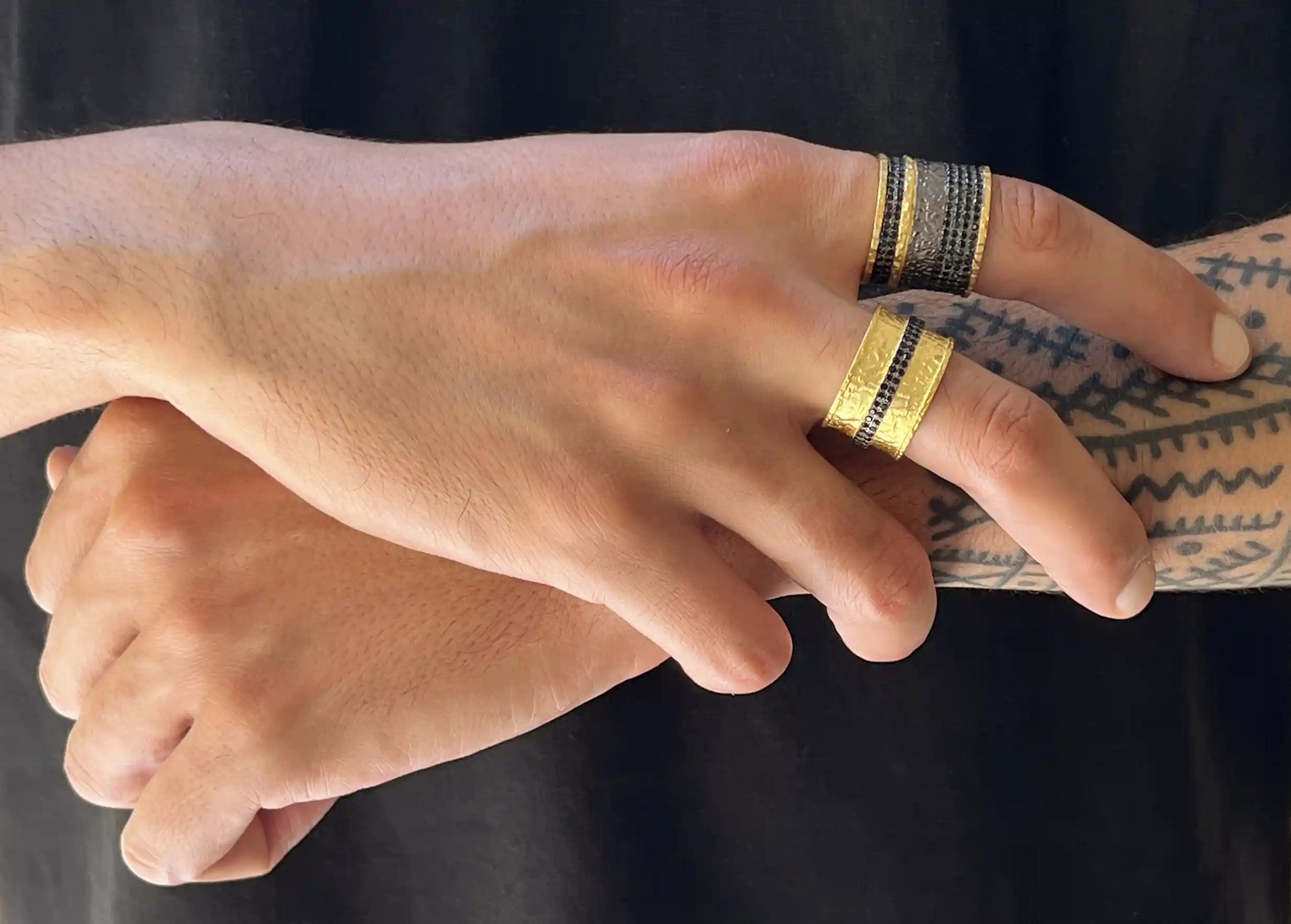 Deux bagues Nuit des Temps en laiton et zirconium portées à la main par une personne