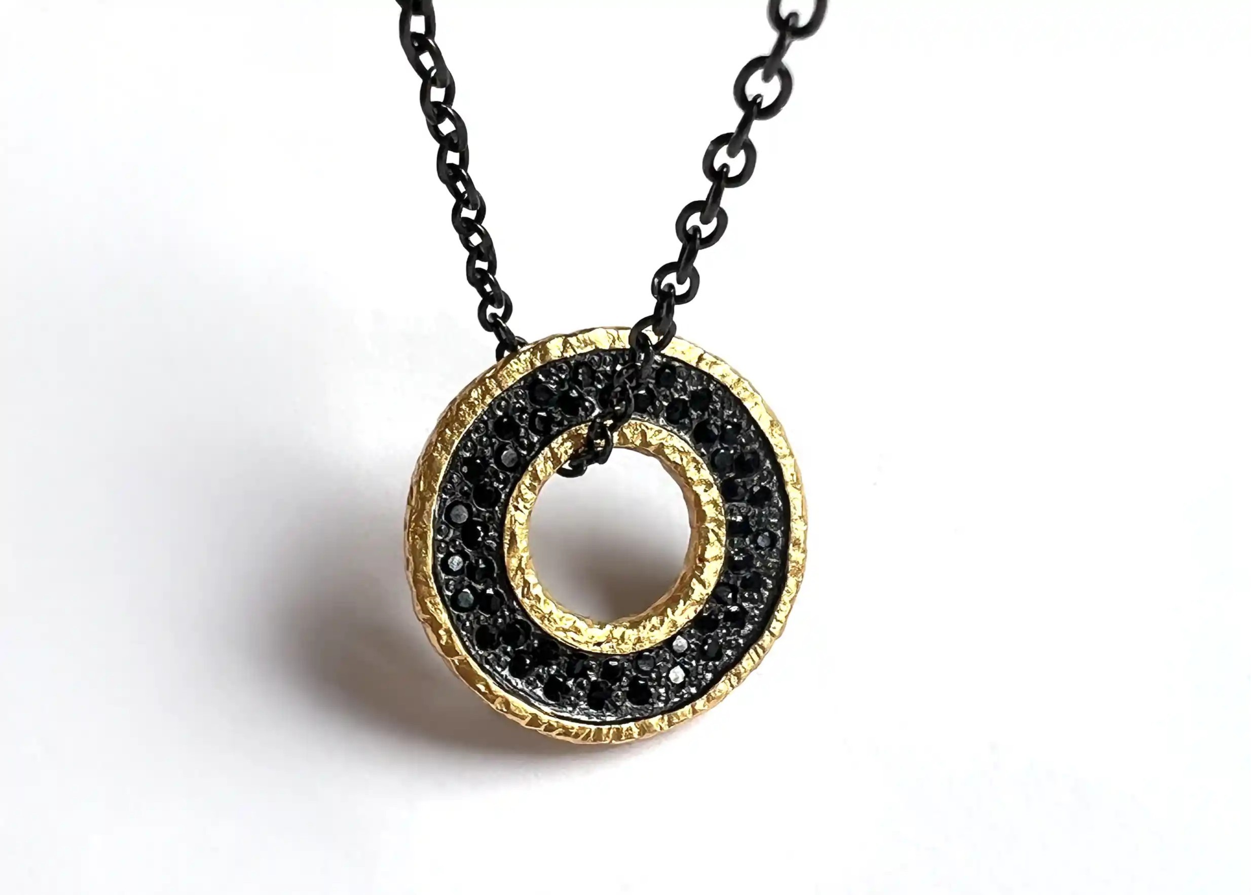 Medallion necklace in brass with black chain and toggle fastening, from the Dawn of Time collection
