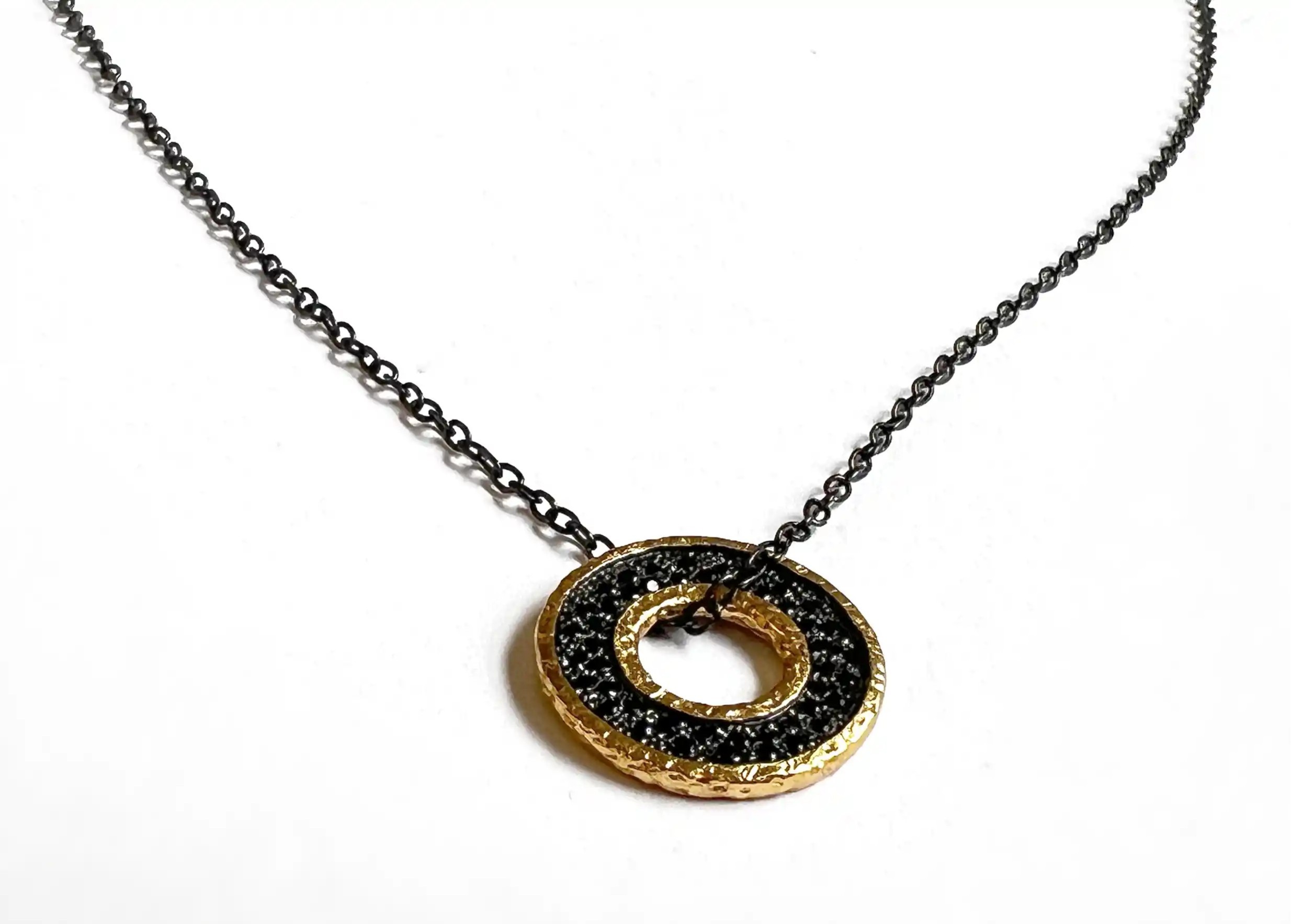 Sautoir médaillon en laiton avec chaîne et incrustrations en zirconium noir, sur fond blanc