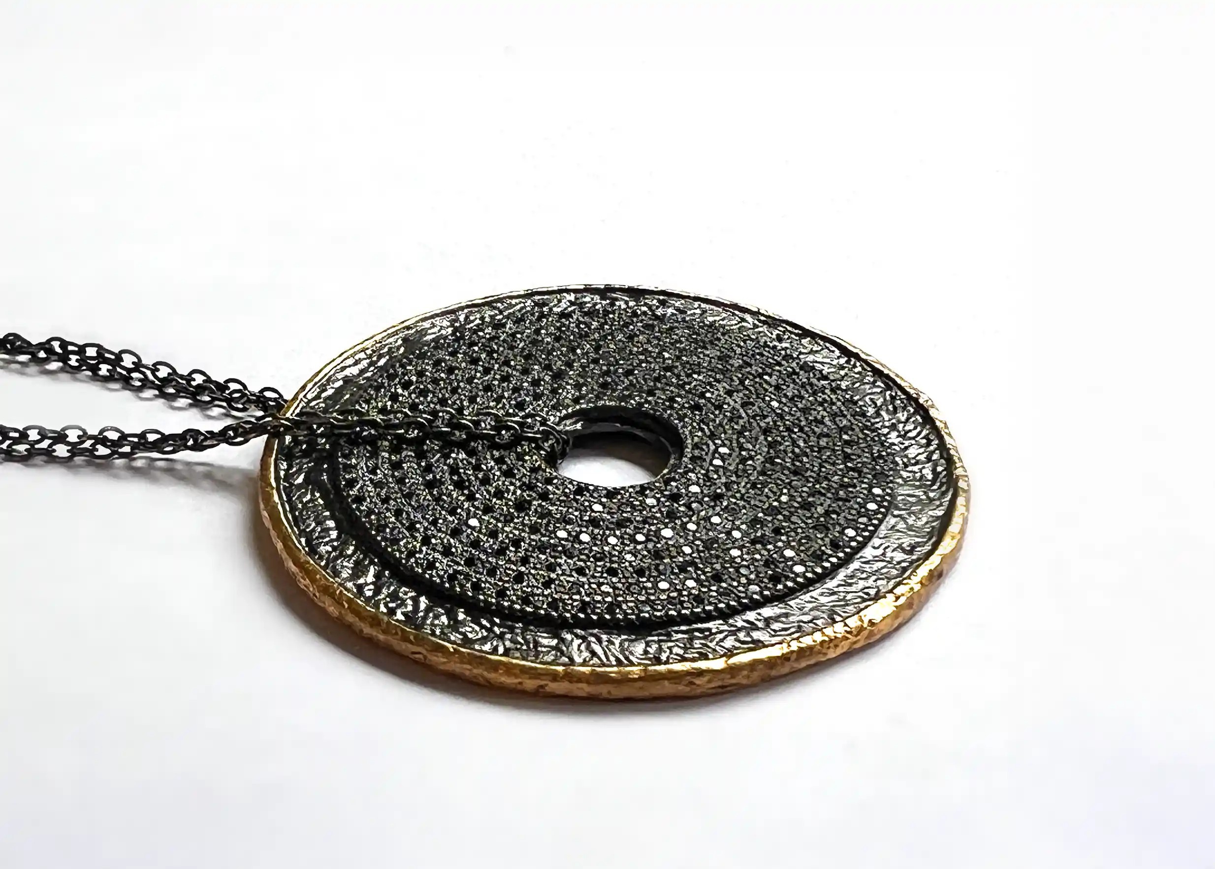 Zoom sur le sautoir talisman en laiton et zirconium, avec double chaine ajustable et fermoir en T, collection Nuit des Temps