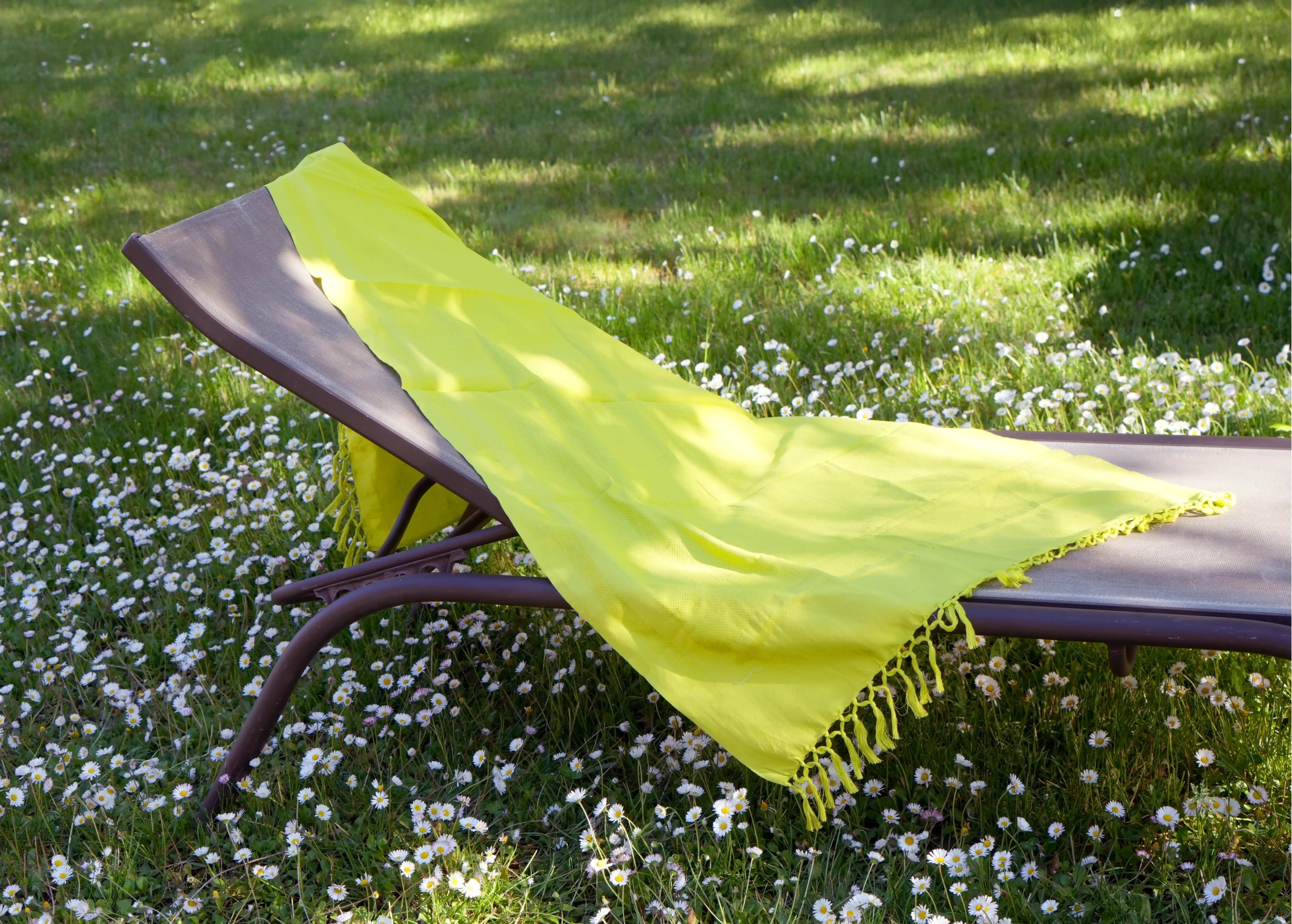 Fouta en coton bio Basilic, collection Kochi, sur un transat dans un parc