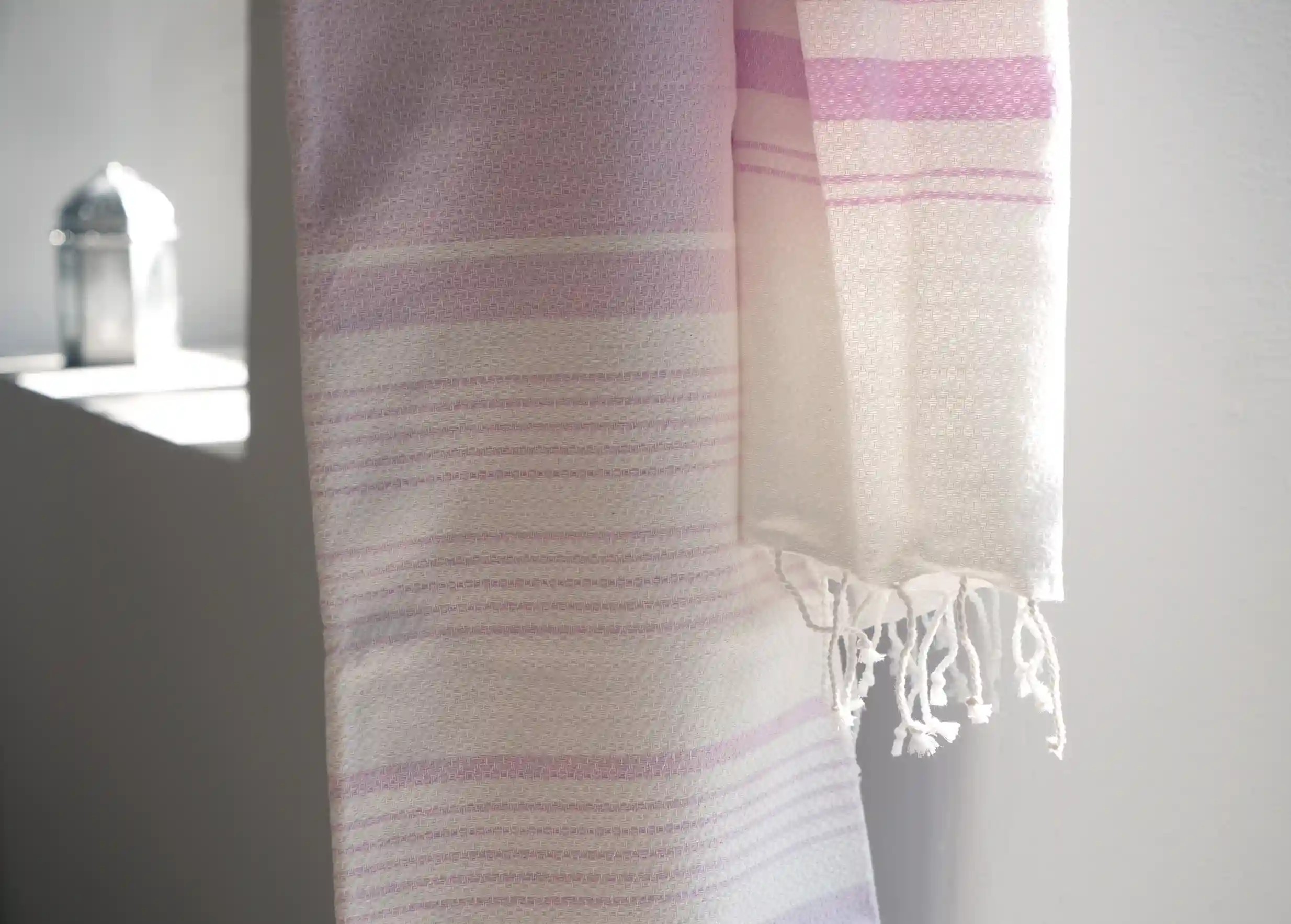 Gros plan sur les finitions artisanales de la fouta en coton biologique Parme de Karawan, tissée sur chaîne blanche