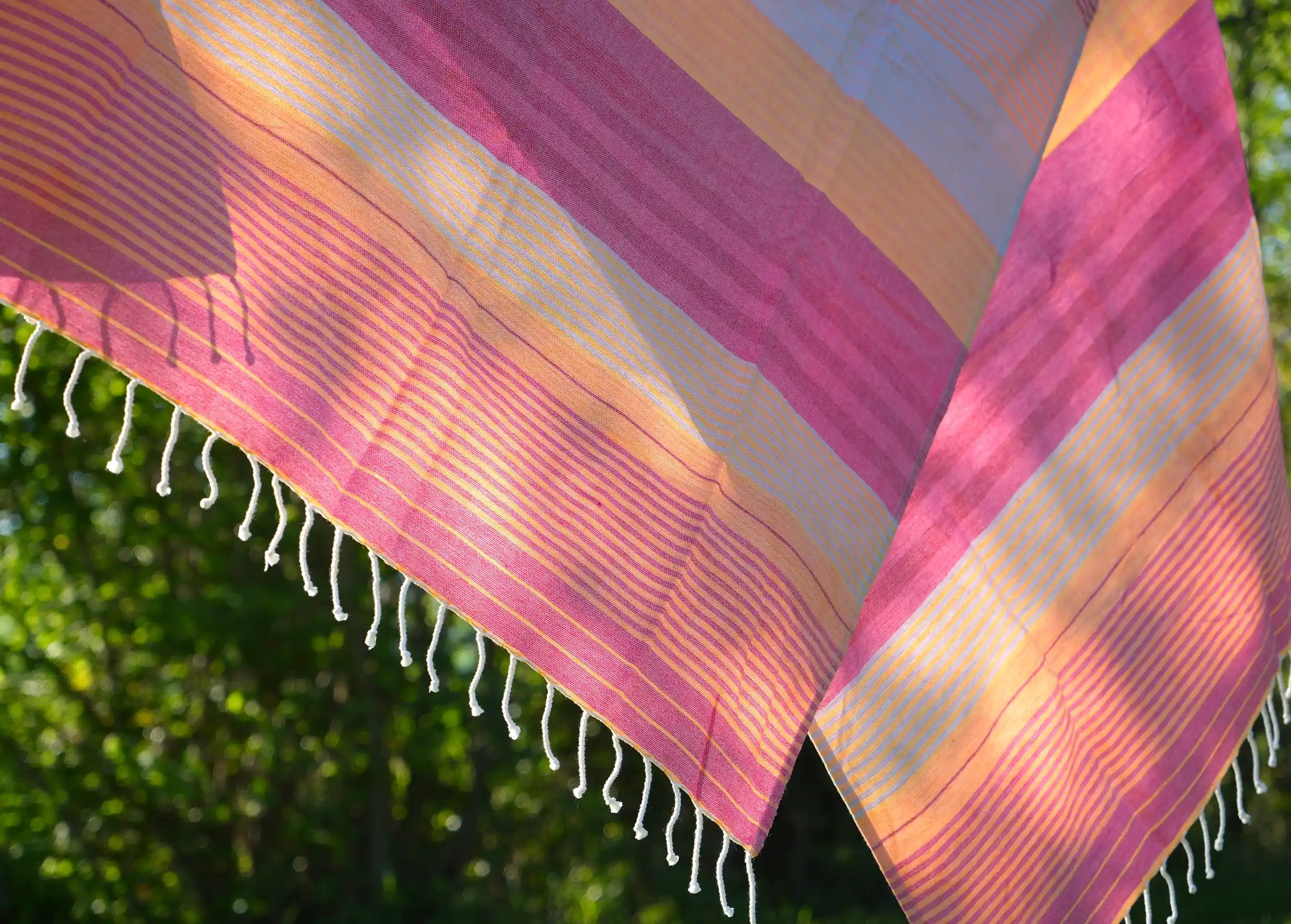 Close-up of the colours and fringes of the azalea-coloured organic cotton fouta from the Sud collection.