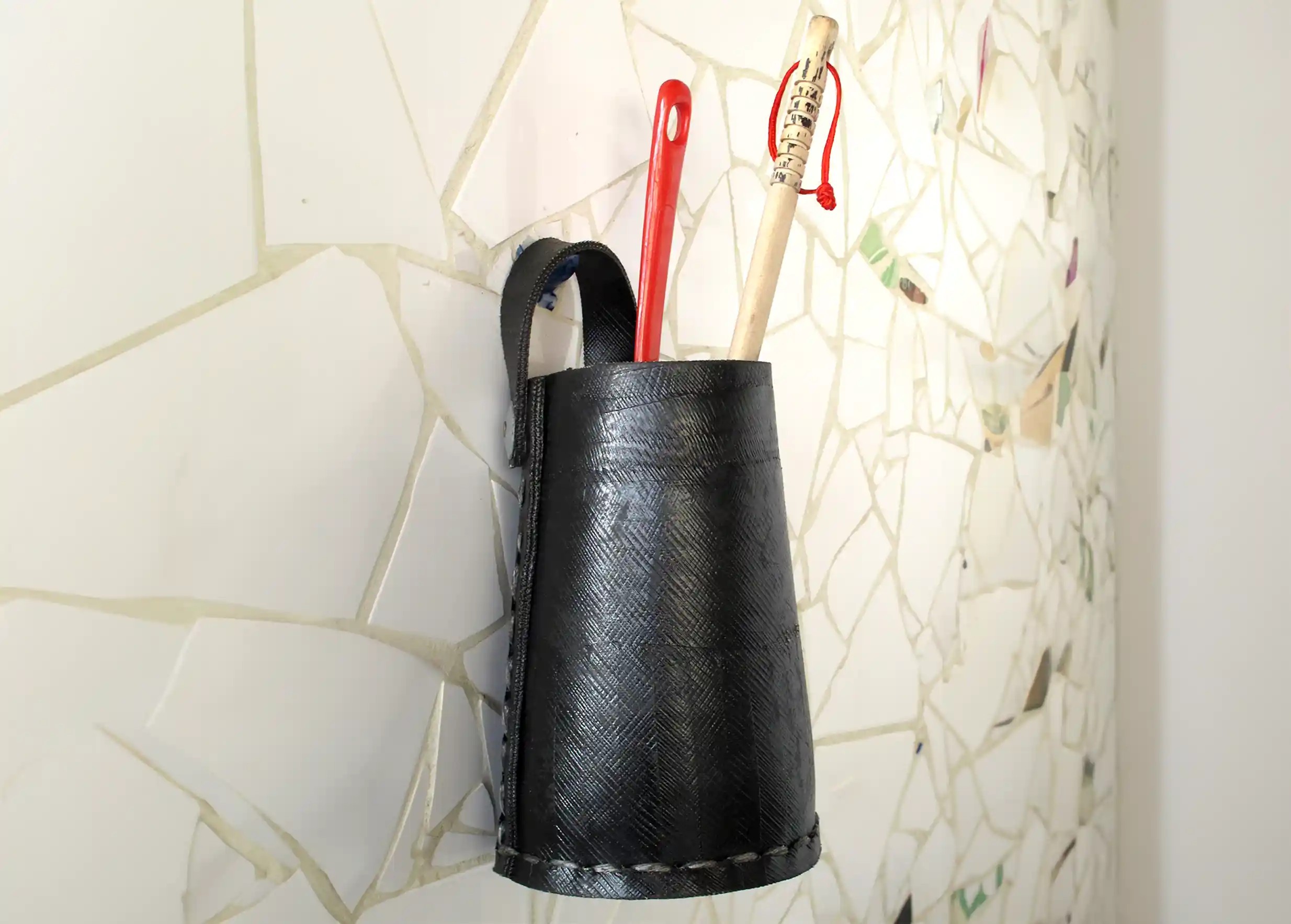 a tall hanging pot made of recycled tyres by Karawan, hanged on the wall