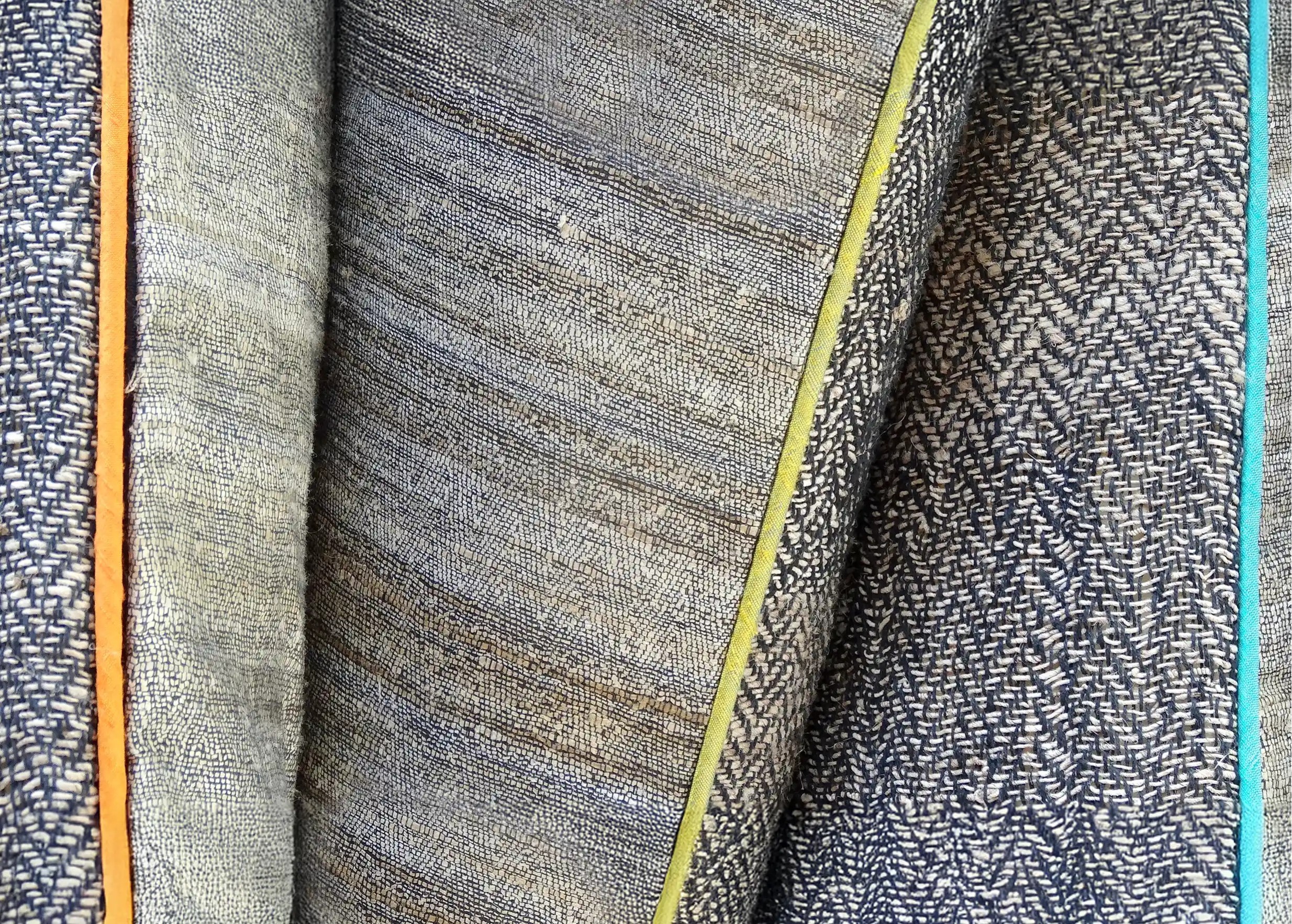 Zoom sur le passepoil couleur safran et bambou de coussins rectangulaires en fibre d'ortie et soie sauvage