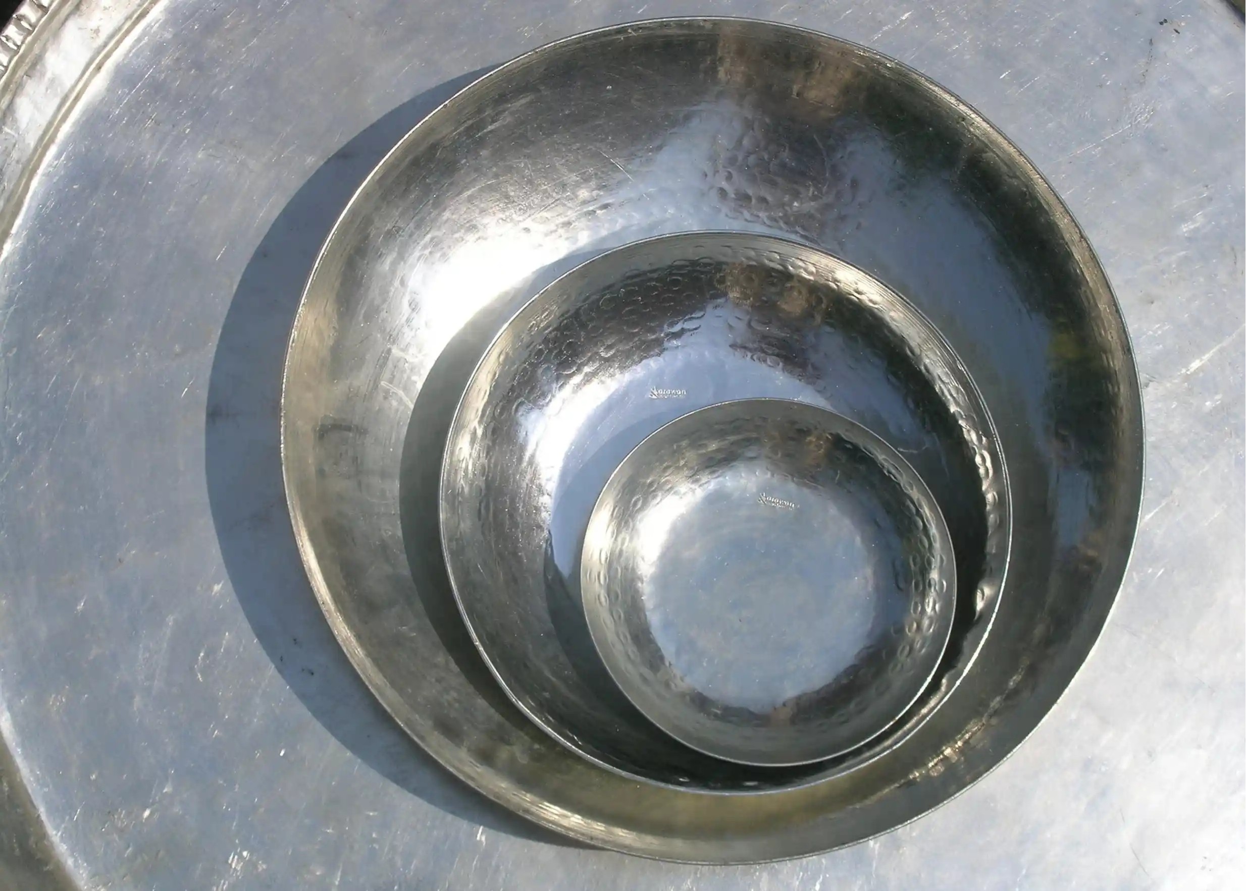 Trois plats en cuivre étamé Luna, de tailles différentes, les uns dans les autres, finition martelée et surface brillante