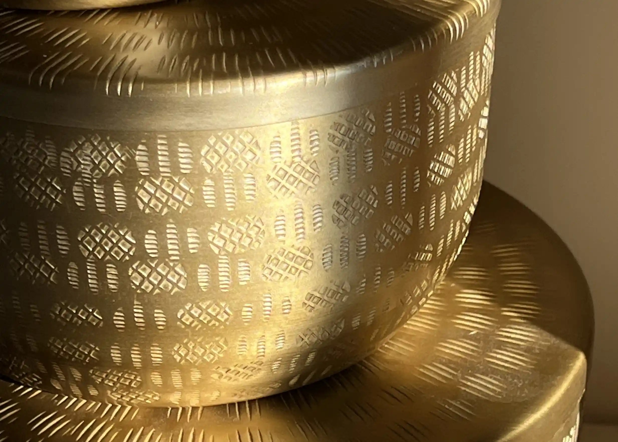 Zoom sur les les motifs gravés et la finition dorée des boites en aluminium recyclé, de la marque Karawan