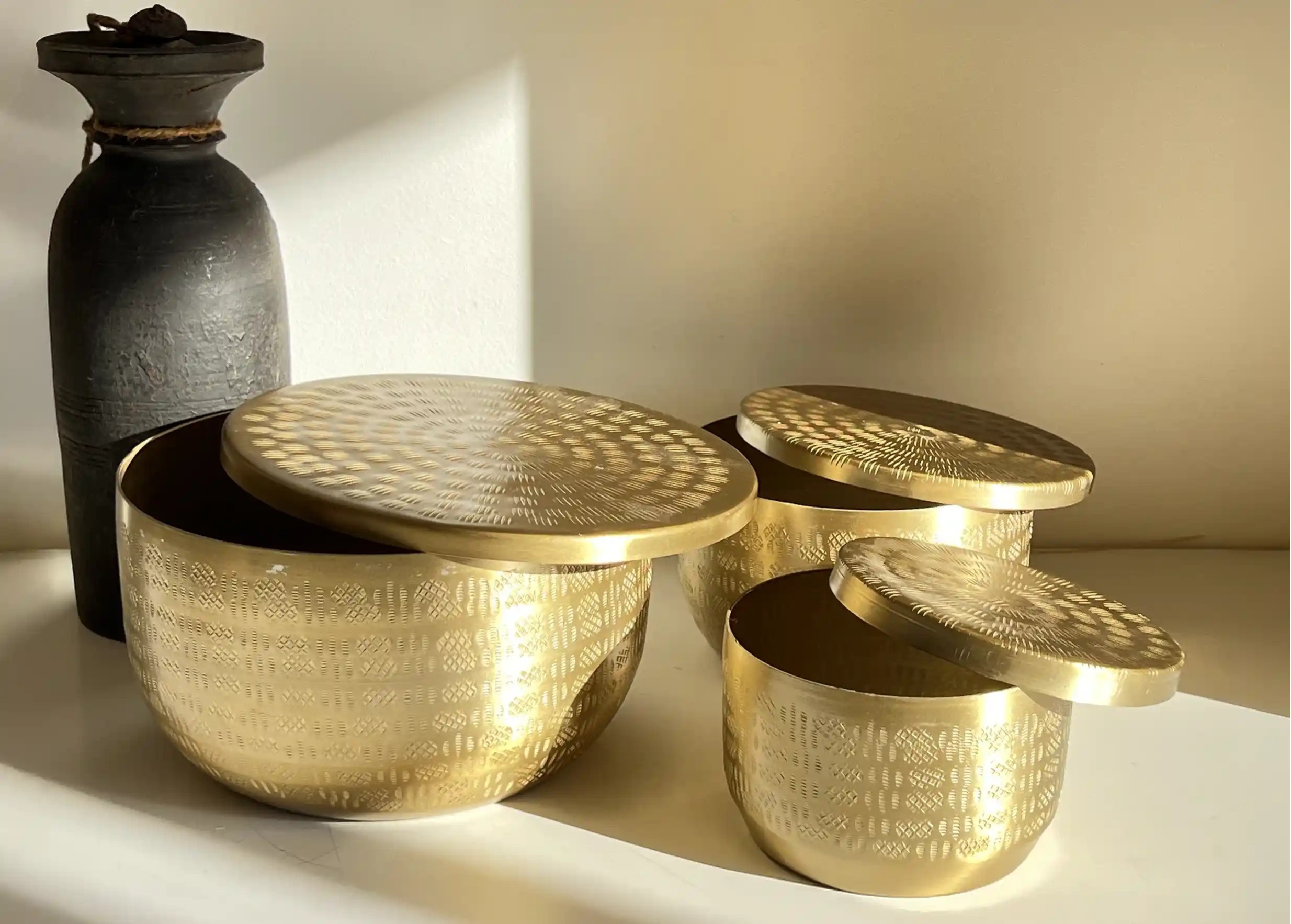 Boites en aluminium recyclé, gravées et au coloris doré, capturant la lumière dans l'ombre, de la marque Karawan