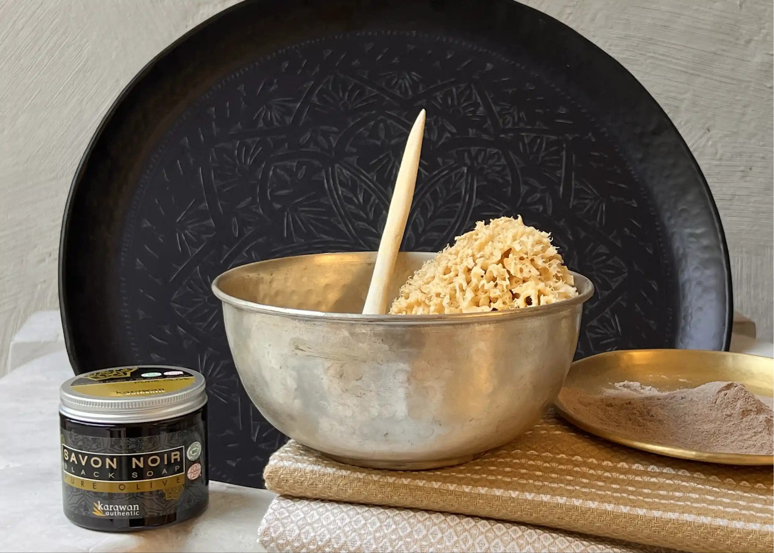 Silver-plated brass bowl with natural sea sponge and wooden ladle, organic cotton fouta, black Karawan tray