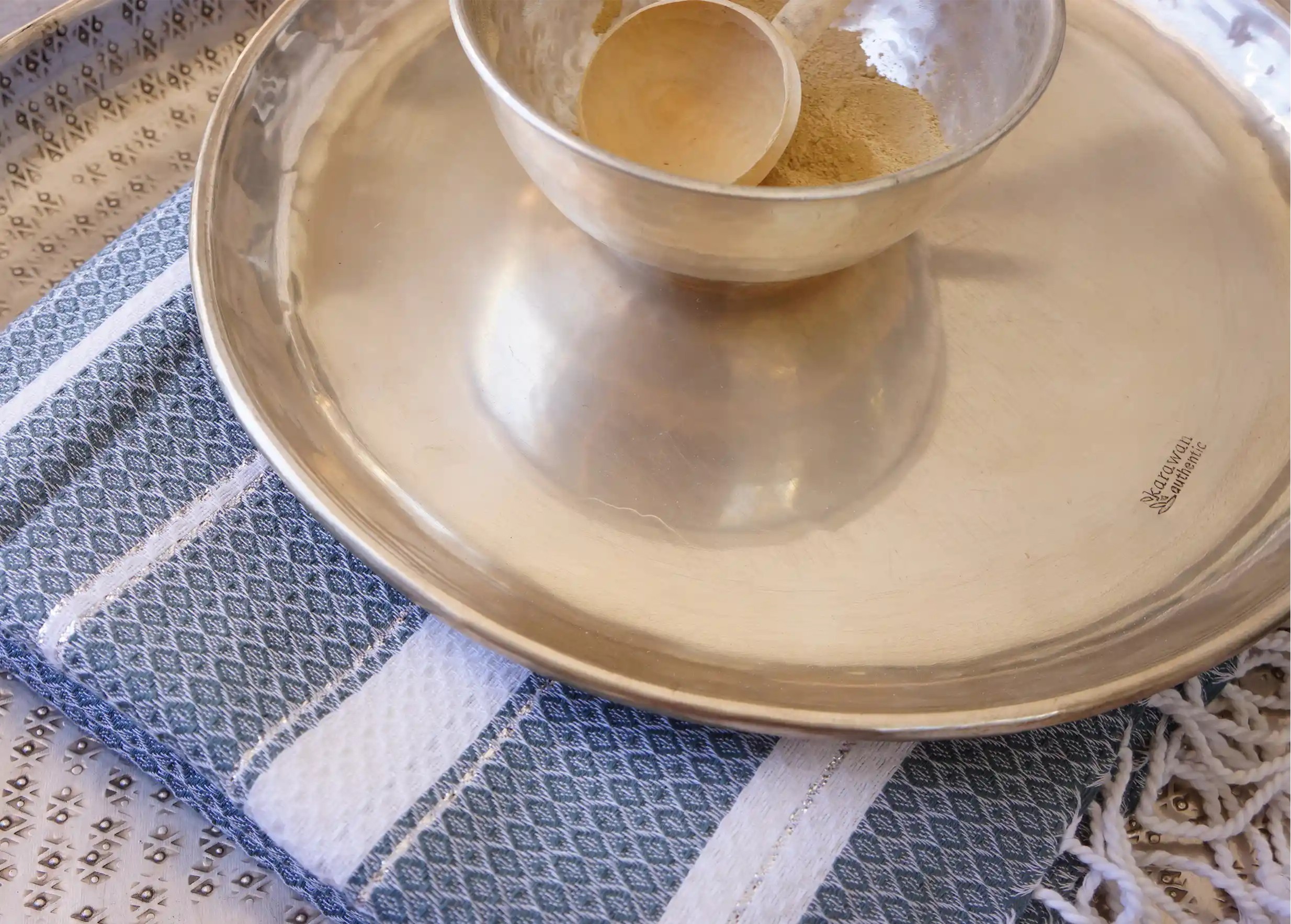 Muz tray with Karawan inscription placed on a cotton fouta, a brass bowl on top