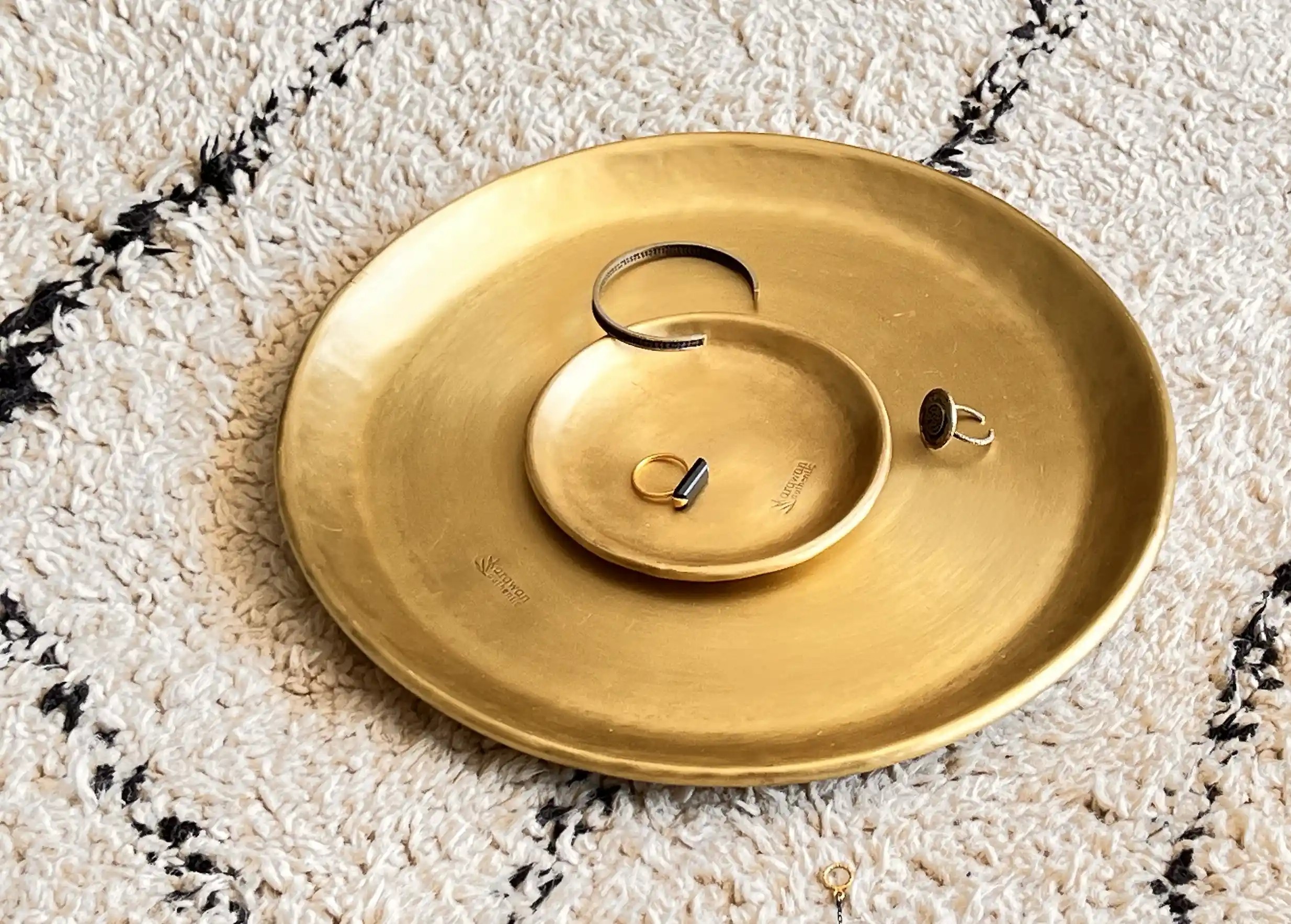 Karawan engraved gilded brass dish, on top of which is a ring and a necklace of fine or semi-precious stones