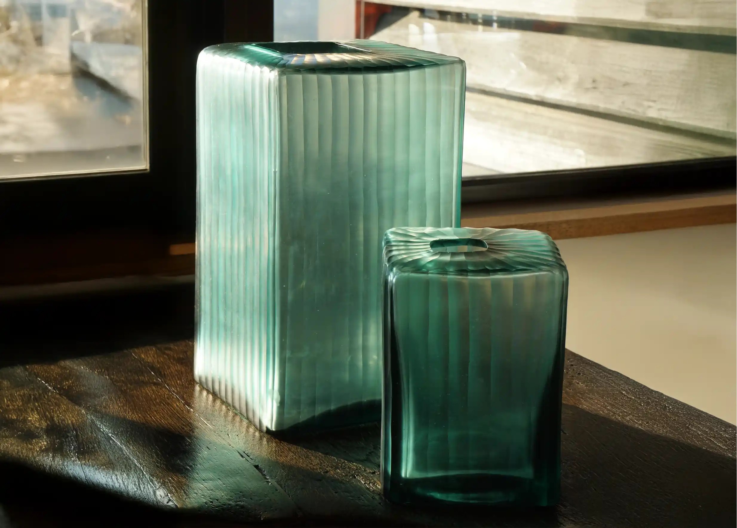 Aqua Cube glass vases on an indoor table, illuminated frame