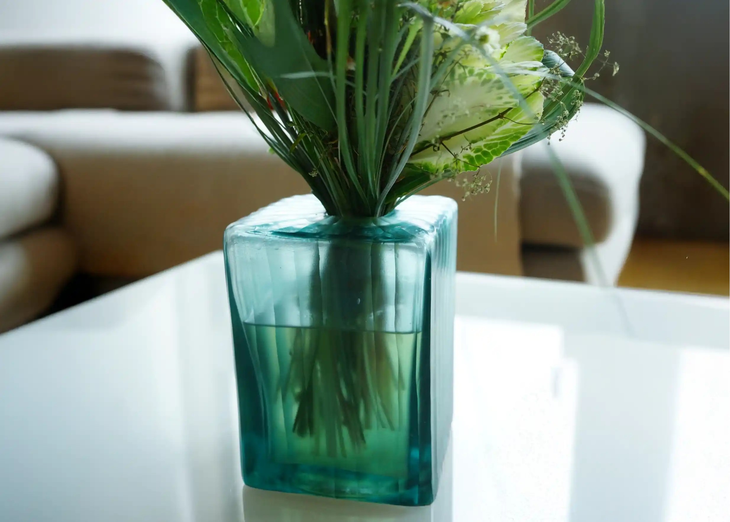 Aqua Cube vase in transparent glass, containing a bouquet of flowers with the stems immersed in water.