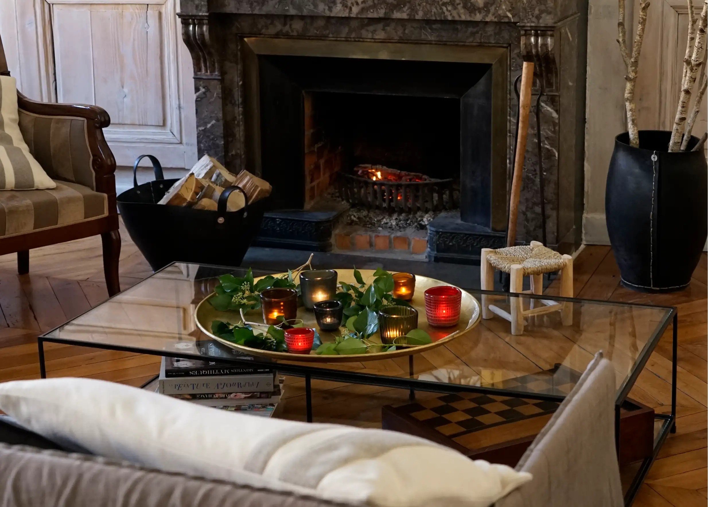 Collection of Karawan blown and recycled glass tealight holders, arranged on a golden tray with leaves in a living room