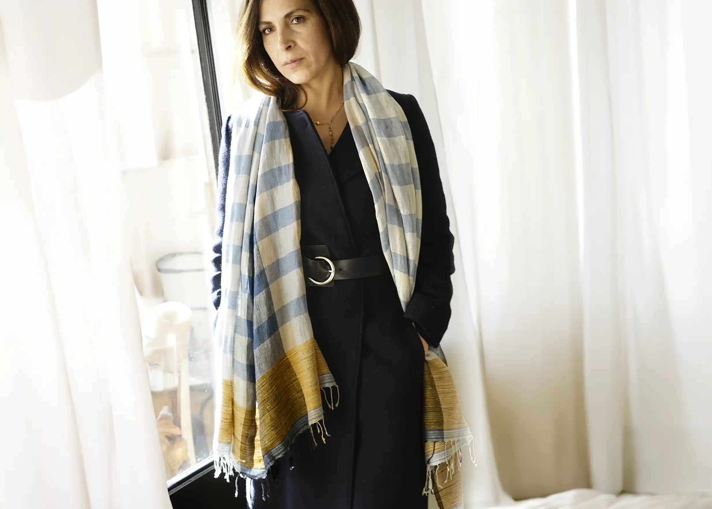 Étole en lin, coton biologique et jute de la collection Chess, portée avec un manteau noir