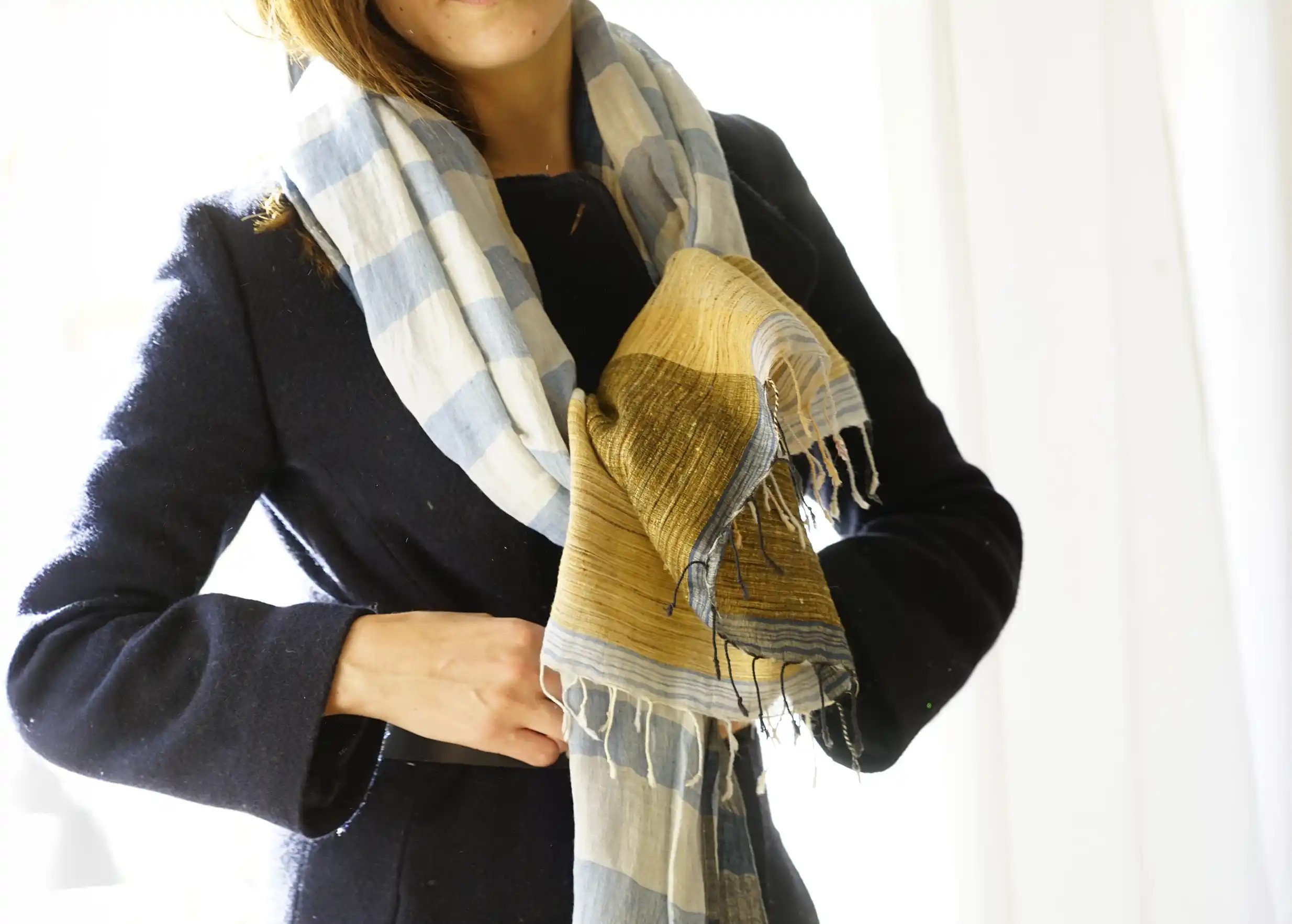 Femme portant sur les épaules une étole en lin, coton bio et jute, coloris bleu mirage