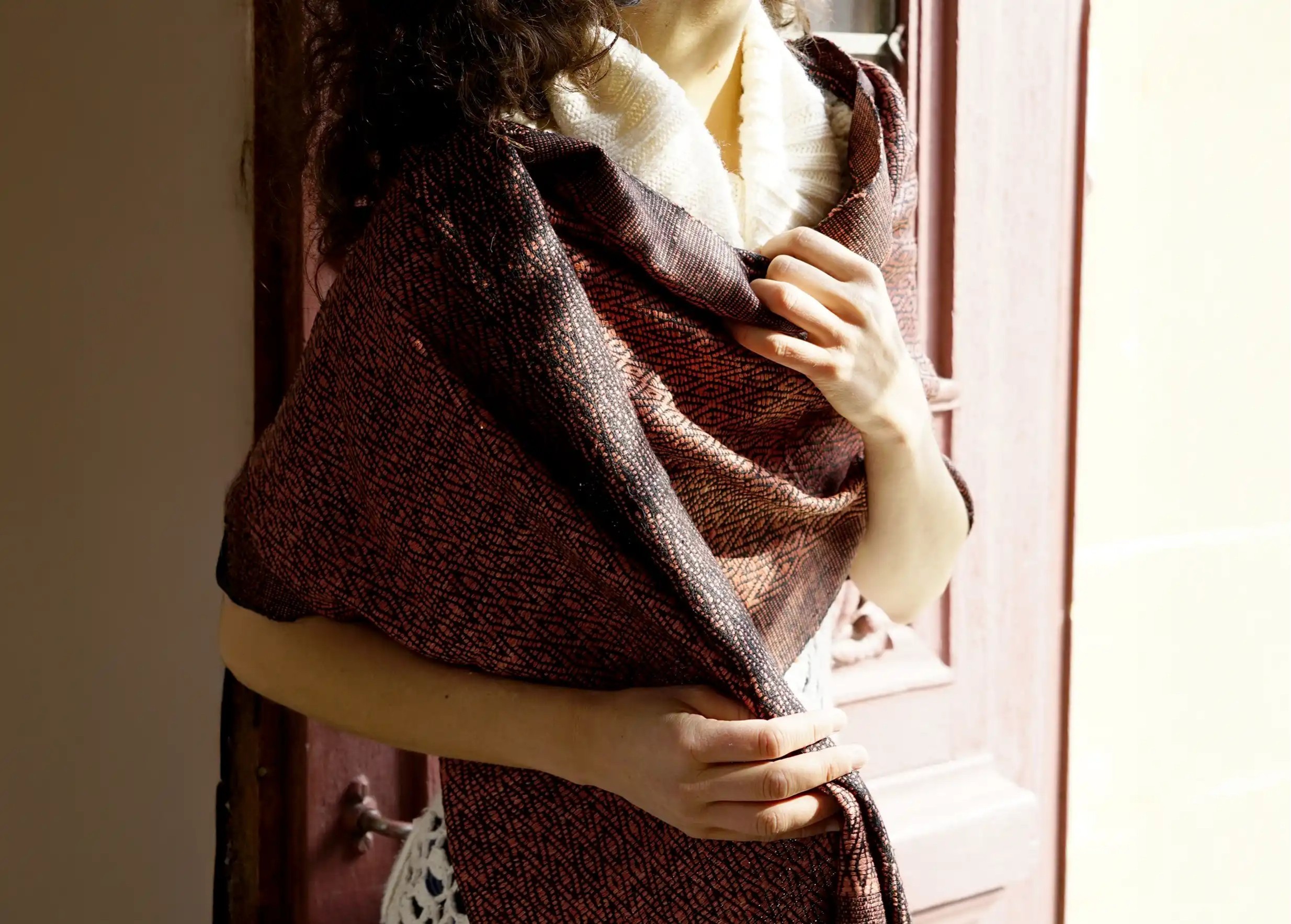 Woman wearing a clay-coloured ‘Eshani’ wild silk stole, standing in front of a wooden door.