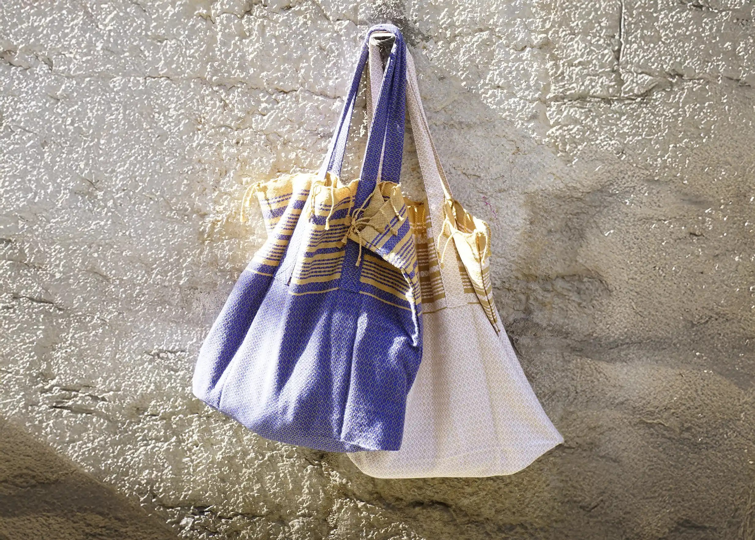 Imperial blue foutabag with sand-coloured stripes, accompanied by a matching organic cotton fouta.