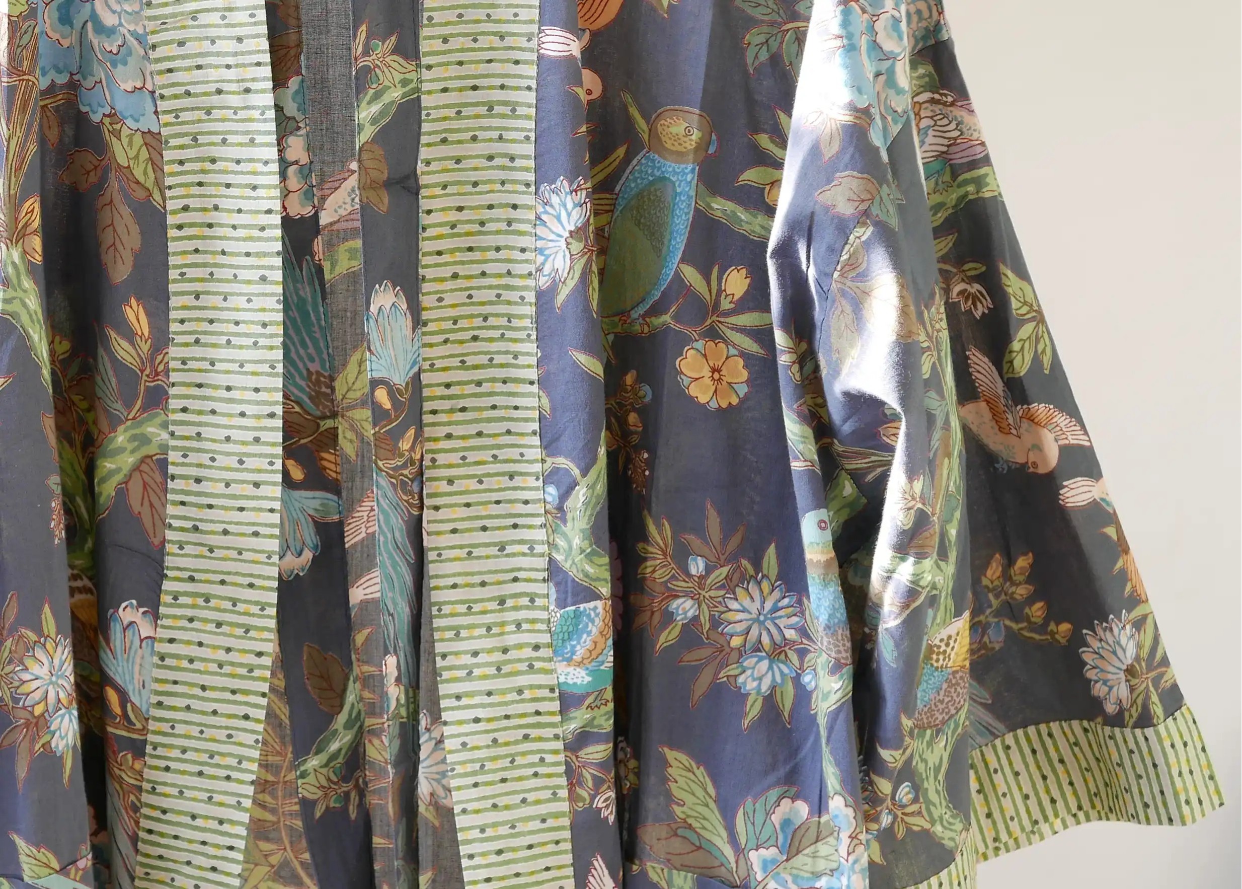 Zoom sur le kimono en coton Paradise Bird, oiseaux colorés et feuillages sur fond sombre, de Karawan