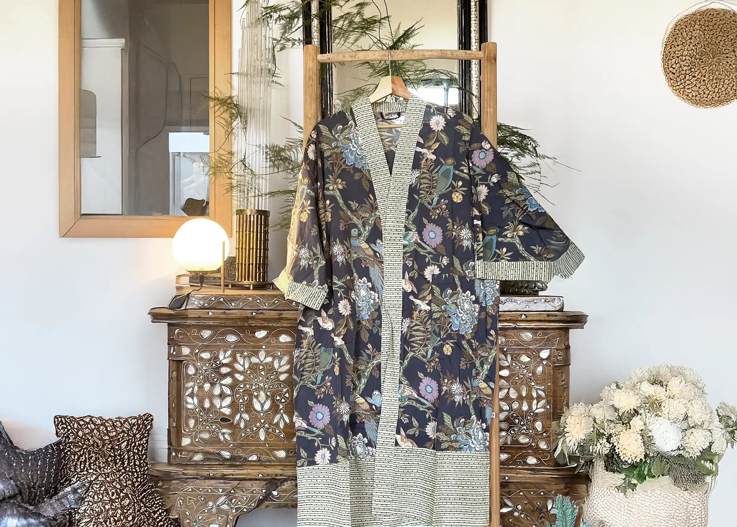 Kimono en coton Paradise Bird, avec des motifs d’oiseaux et de feuillages colorés, plantes luxuriantes à côté