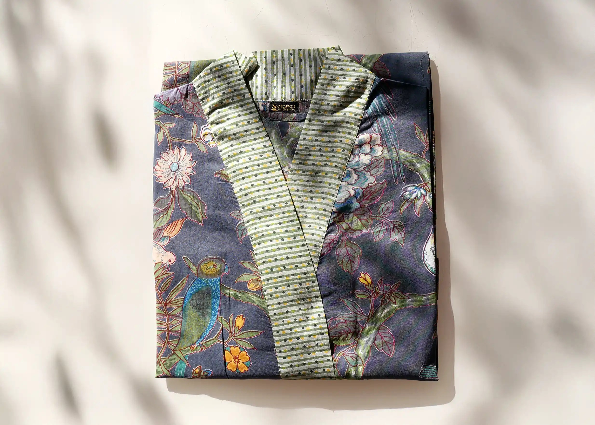 Kimono plié en coton Paradise Bird porté, avec des motifs d’oiseaux et de feuillages colorés