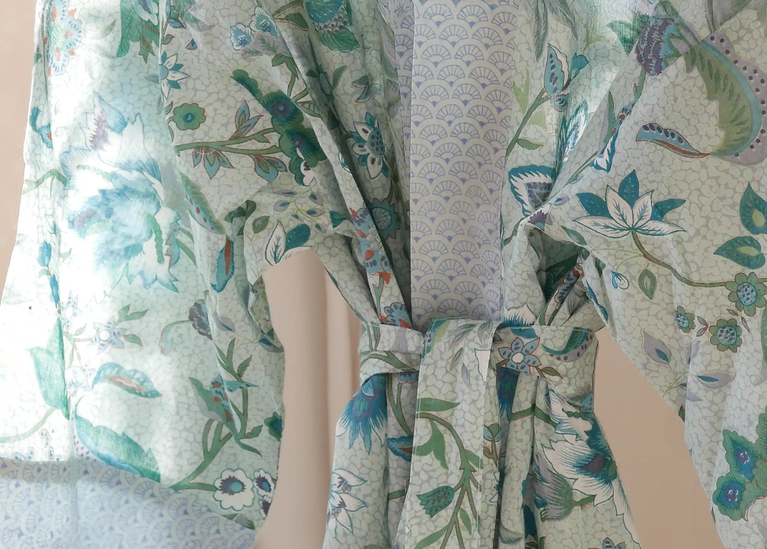 Close-up of a Karawan cotton kimono, delicate, colourful floral motifs on a light weave
