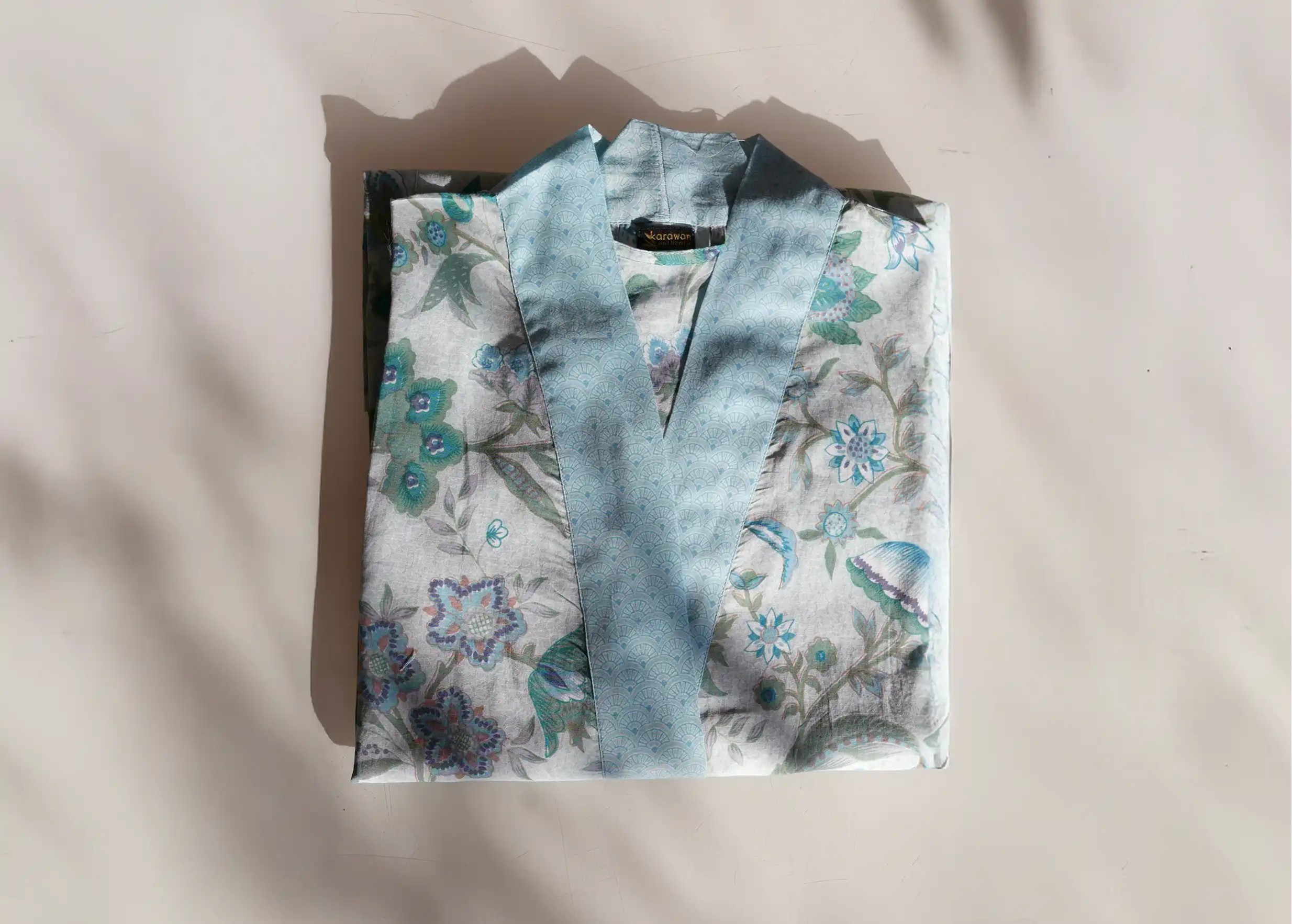 Detail of a Blue Garden cotton kimono, blue and green floral motifs on a light background