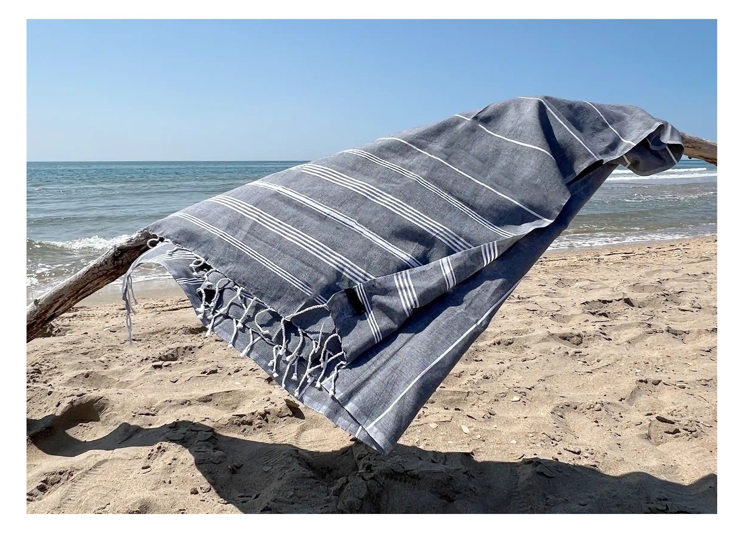 Fouta en coton bio coloris anthracite, sur une plage Fouta en coton bio coloris anthracite, sur une plage