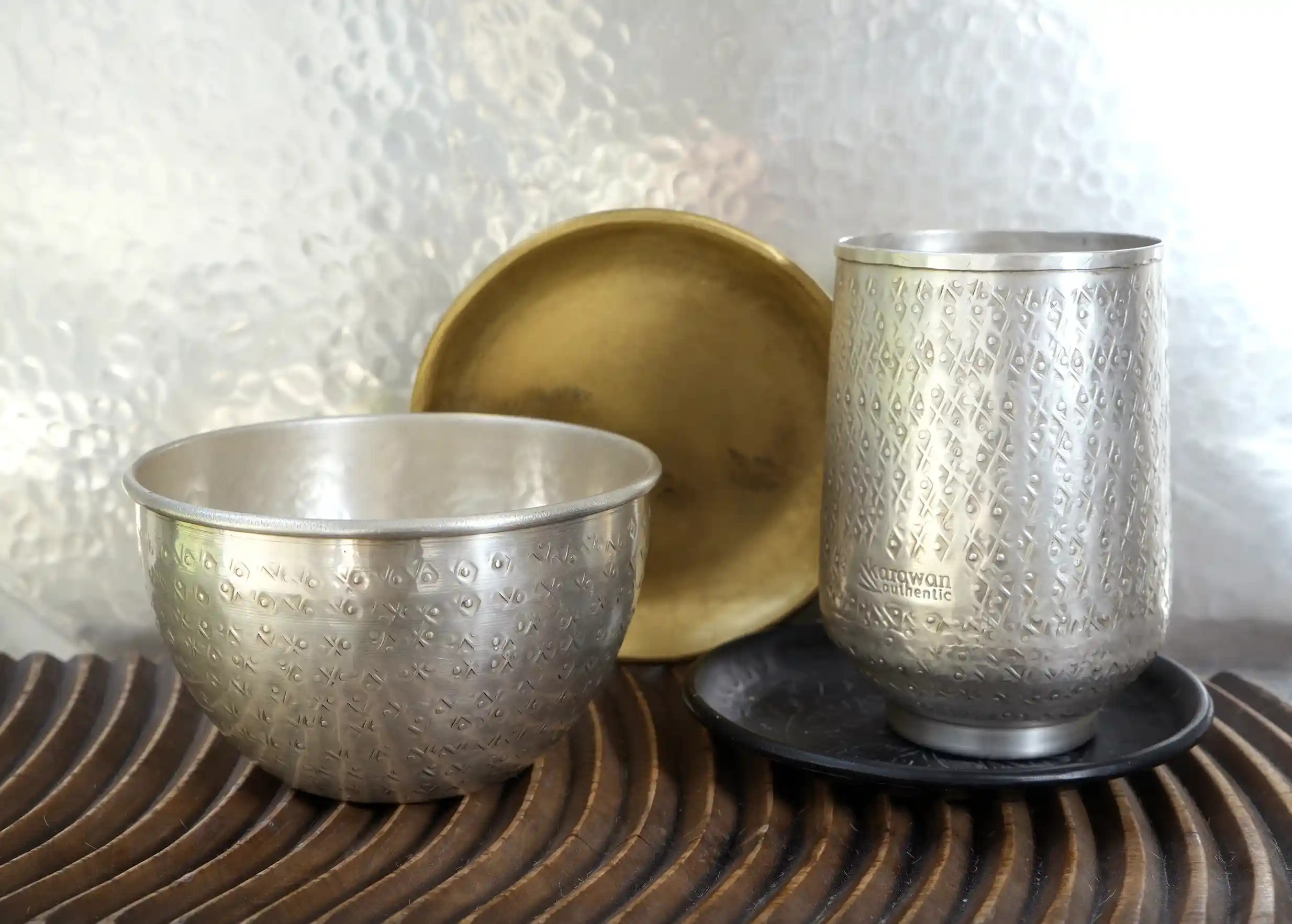 Assortment of engraved, hammered brass decorative objects with a hand-crafted finish, by Karawan