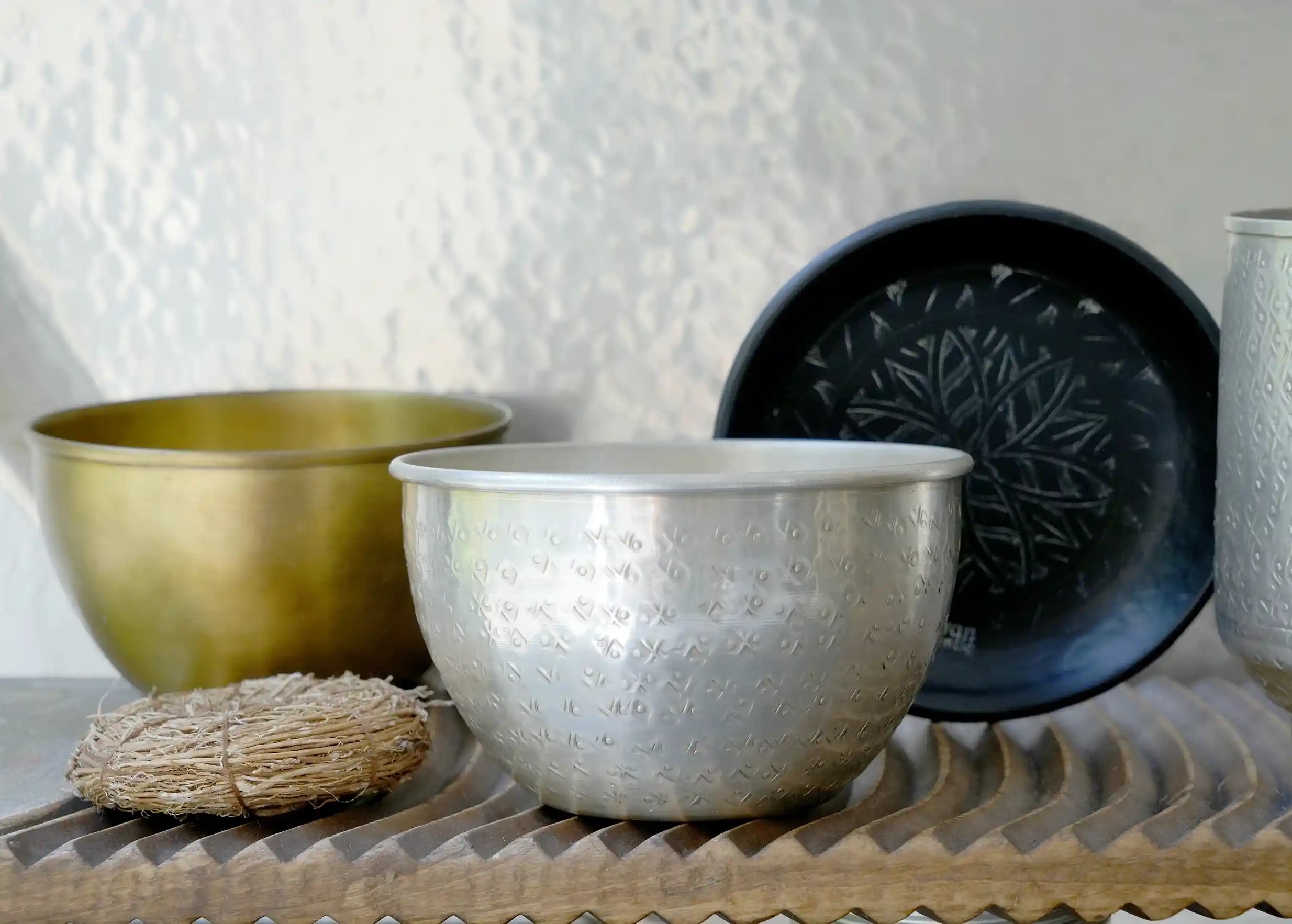 Assortment of engraved and hammered brass decorative objects, trays, brass glass and bowls, from Karawan