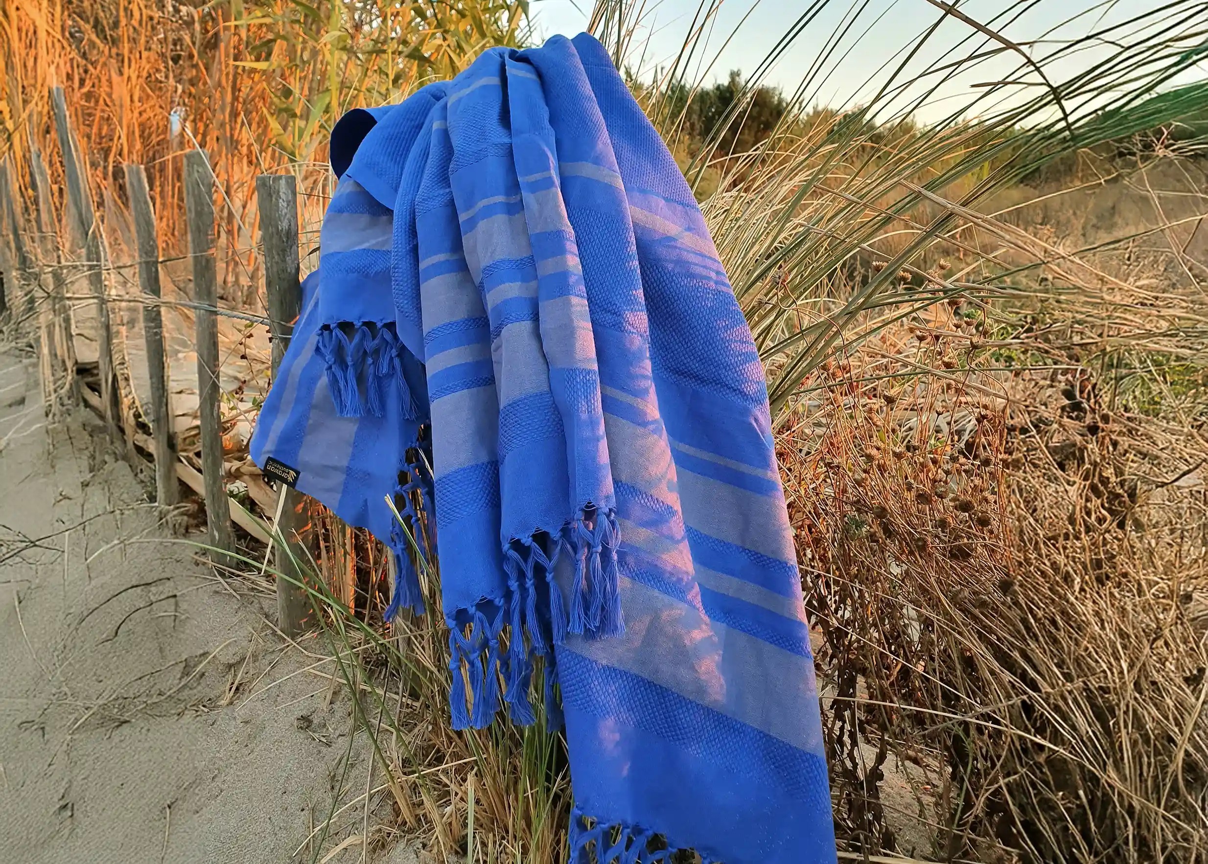 Fouta in beige blueberry organic cotton suspended and floating in the wind