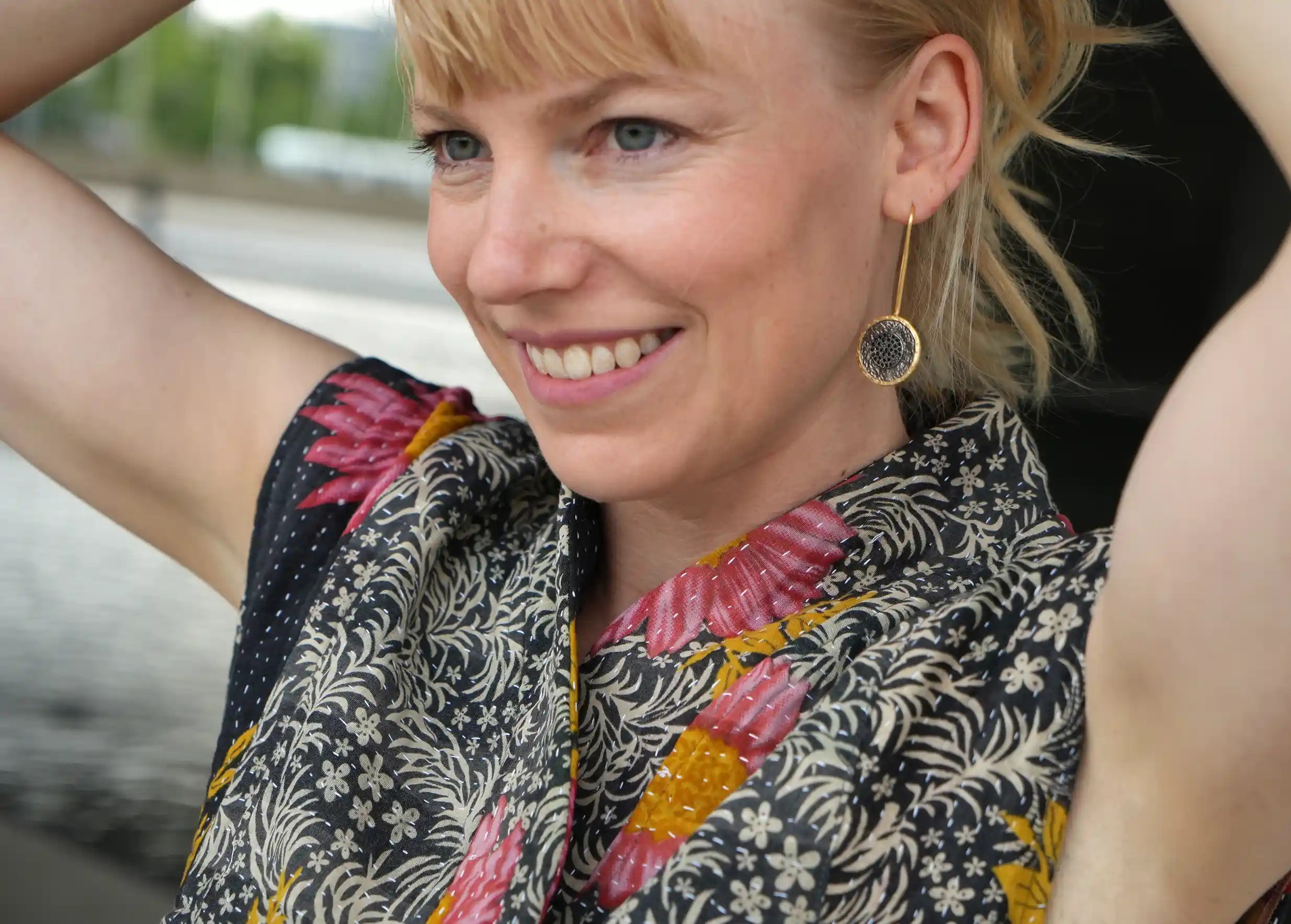 Gros plan sur le visage d’une femme souriant, qui porte un gilet kimono en coton Kanta matelassé