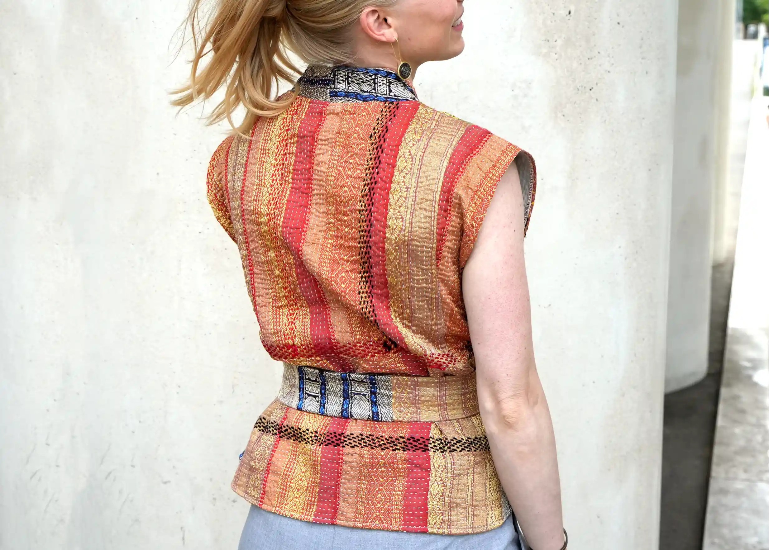 Femme de dos, cheveux attachés, qui porte le gilet Karawan en soie et coton Kanta