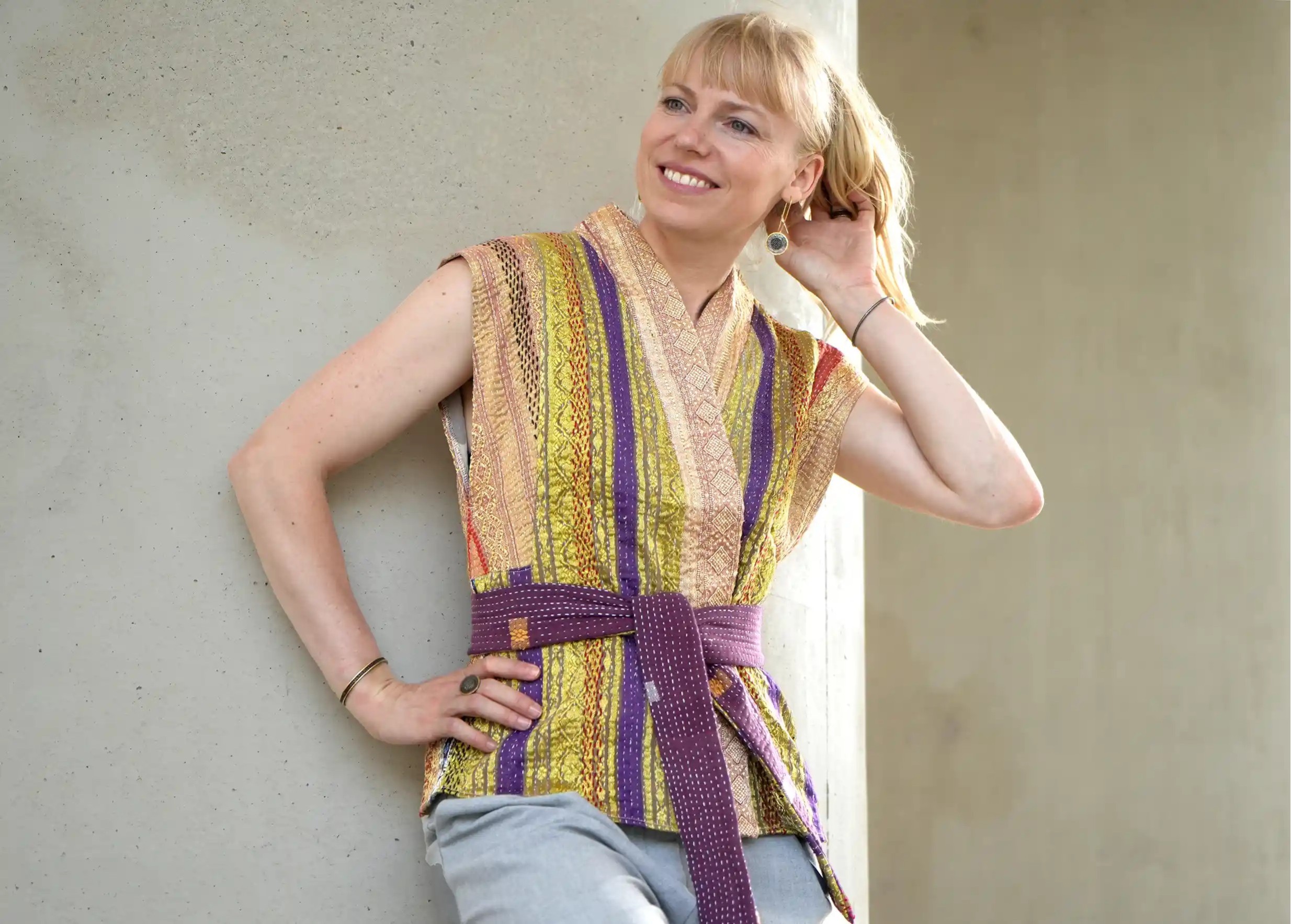 Woman against a wall outdoors, wearing a quilted cotton kimono waistcoat