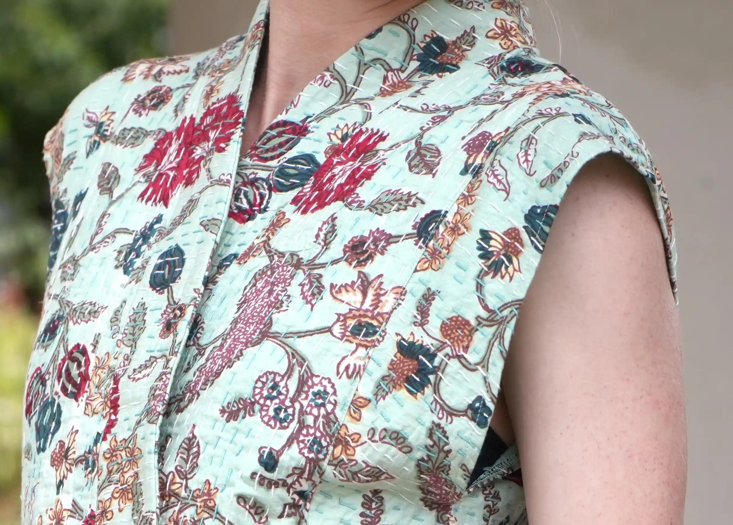 Focus on the exotic floral motifs on the sleeveless kimono waistcoat by Karawan authentic