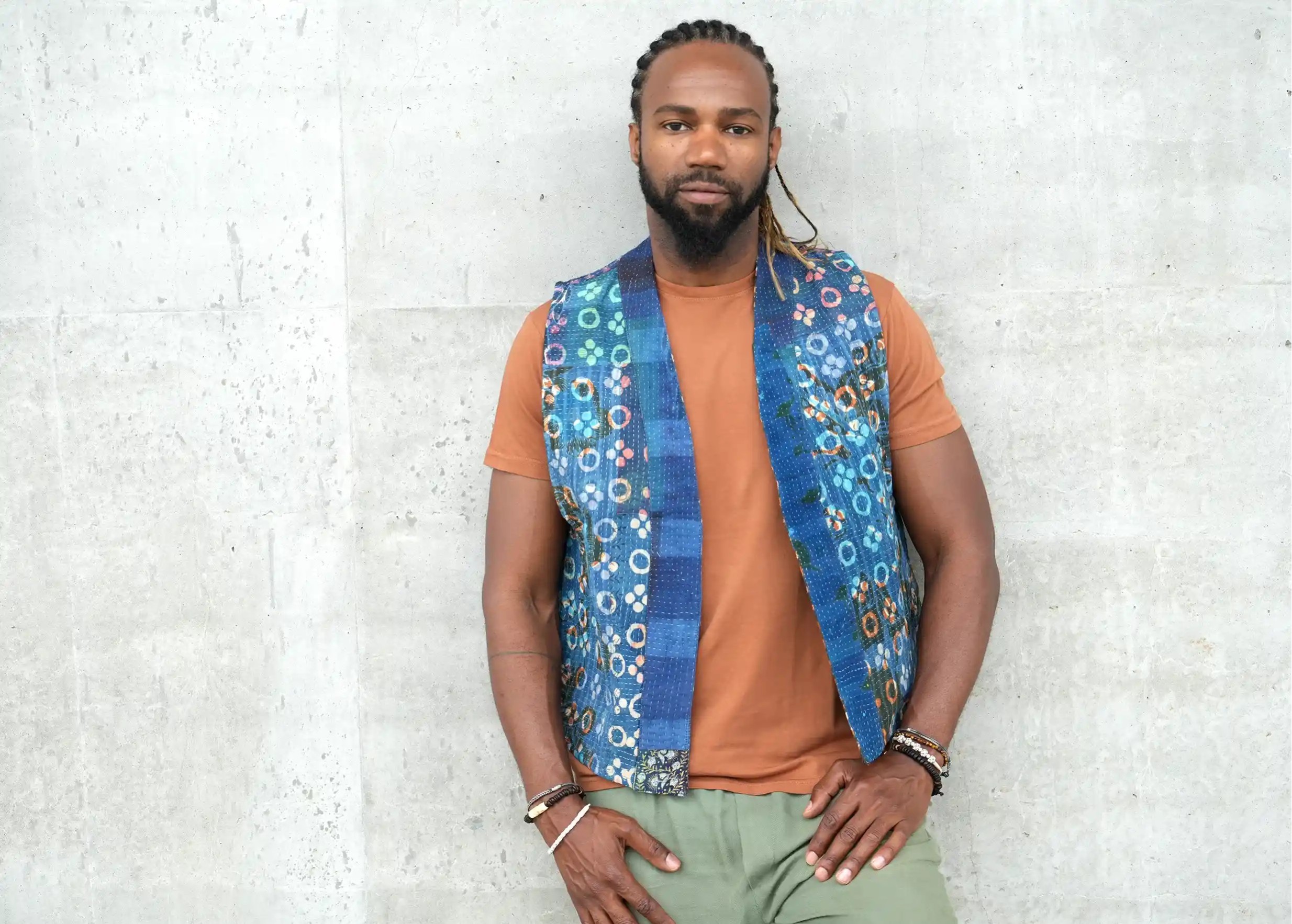 Man against a textured wall wearing a reversible quilted cotton kanta bolero