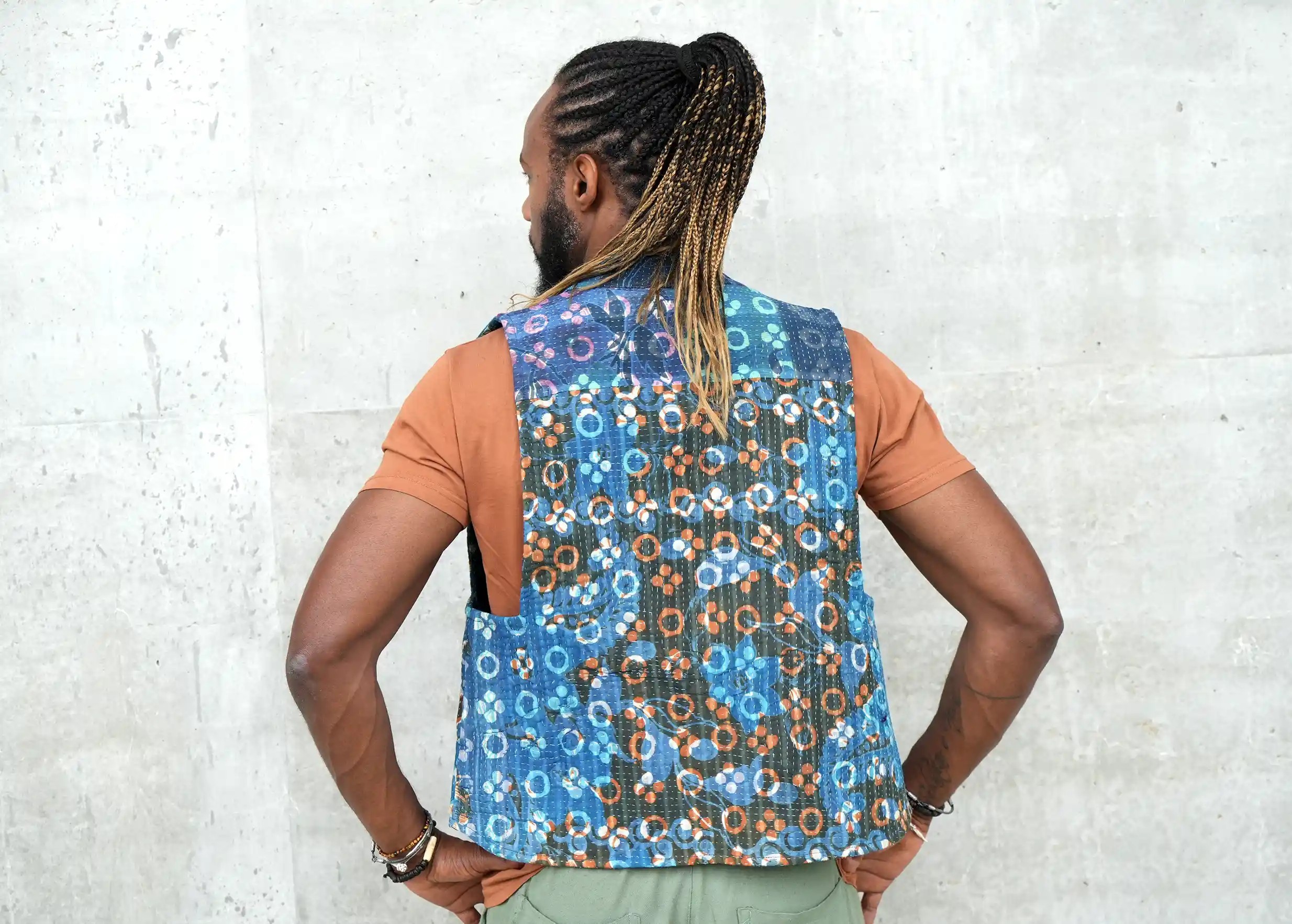 Man from the back with his hands on his hips, wearing a bolero with plant motifs in quilted cotton kanta