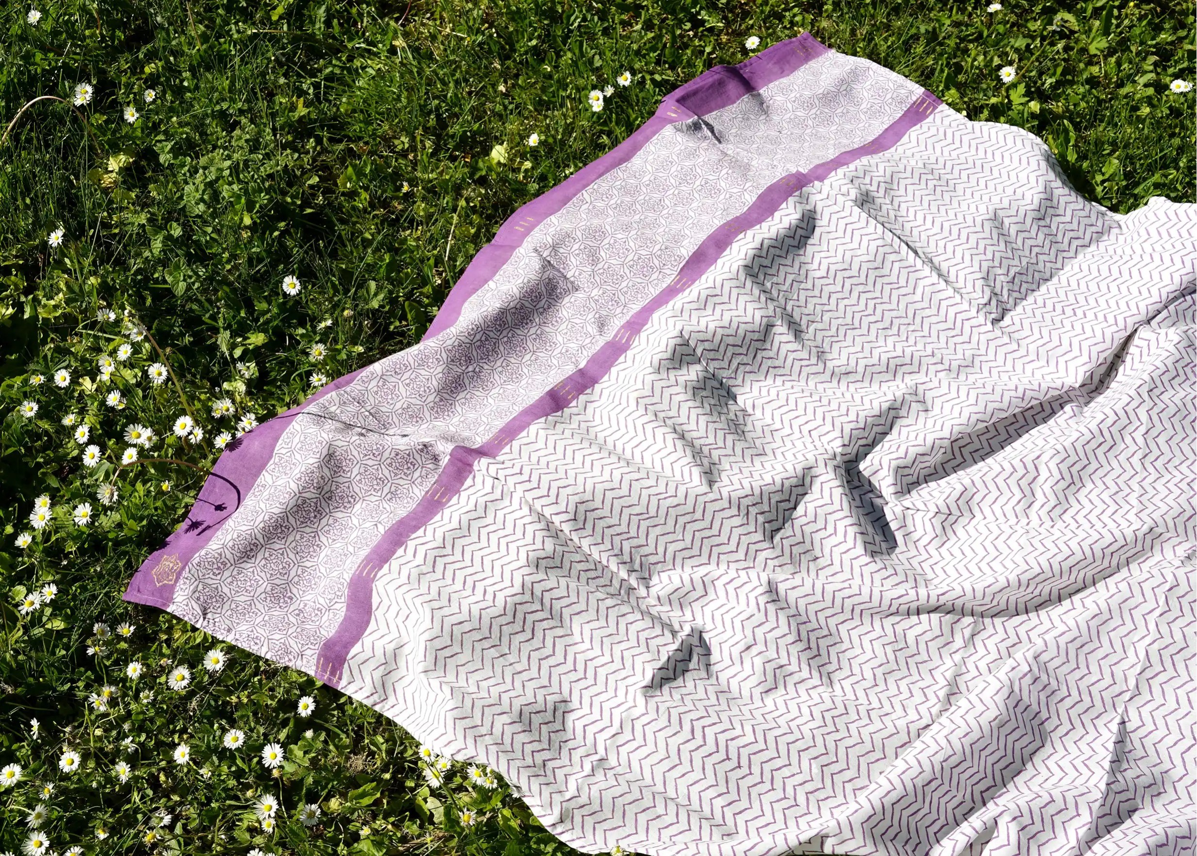 ‘Zigblock’ cotton pareo, pad-printed in plum colour, laid out on the grass