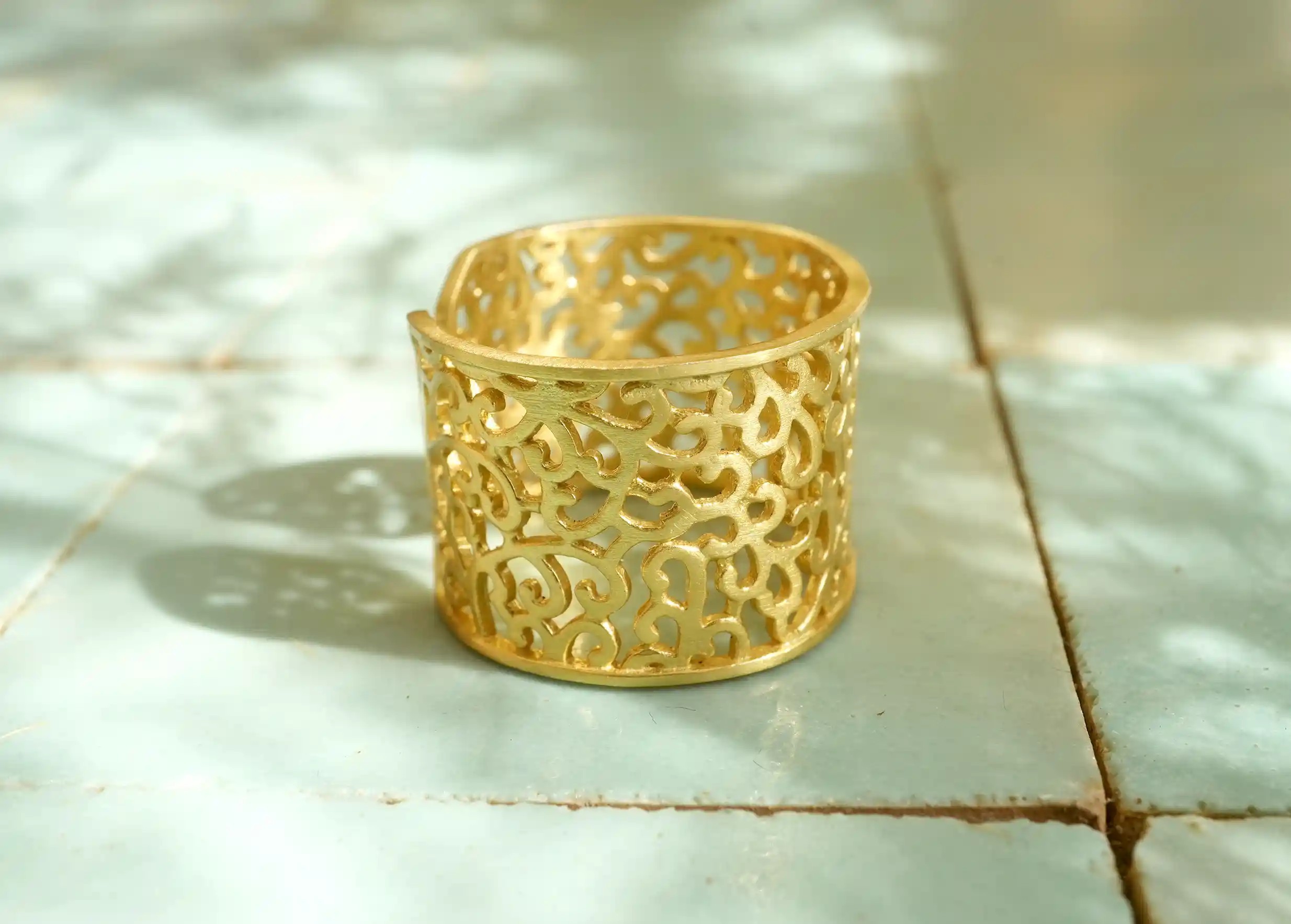 Adjustable ring in gilded-plated brass on blue tiles, by Karawan