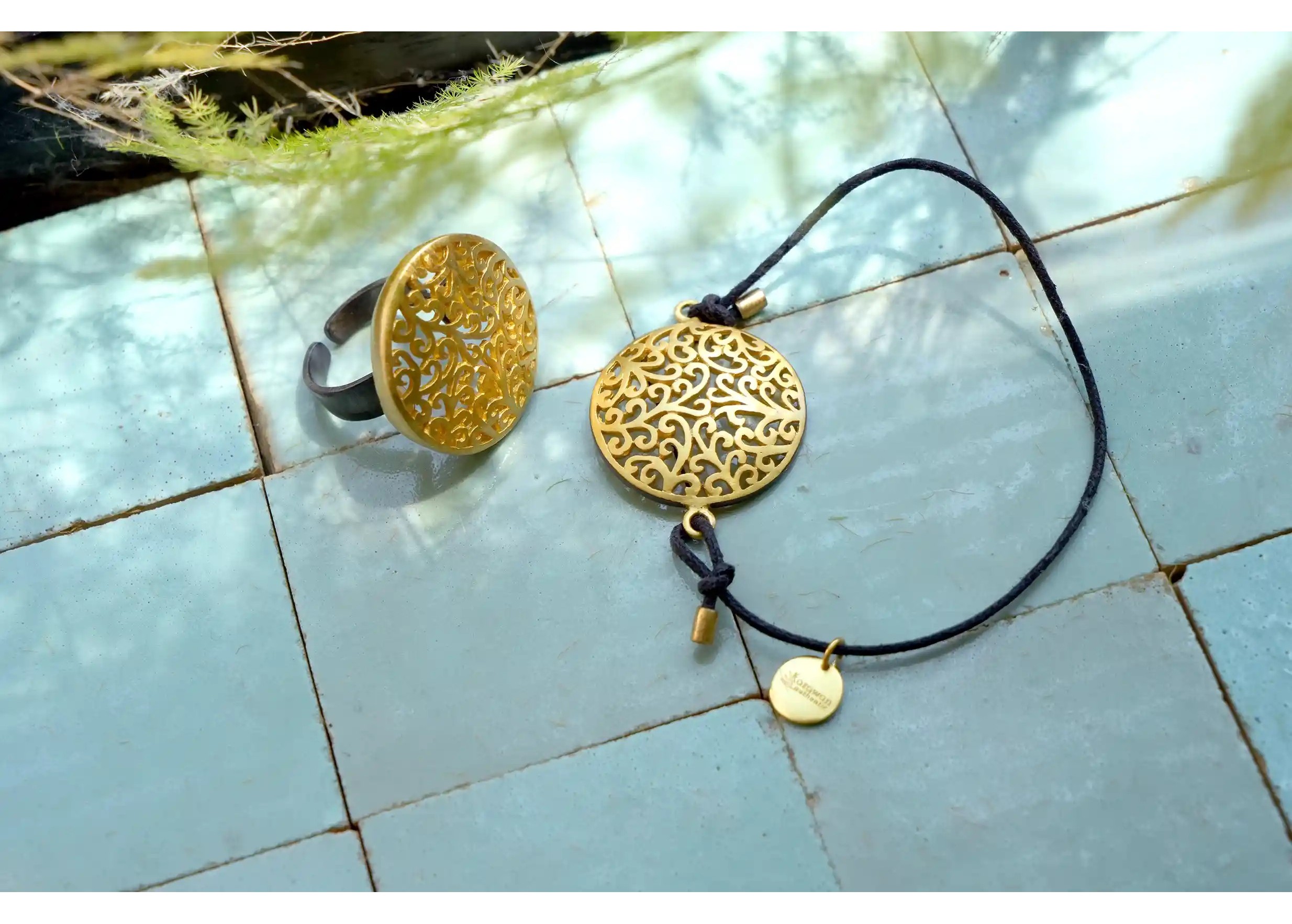 Secret Garden brass bracelet and ring, viewed from the front, featuring a geometric design with a golden effect.
