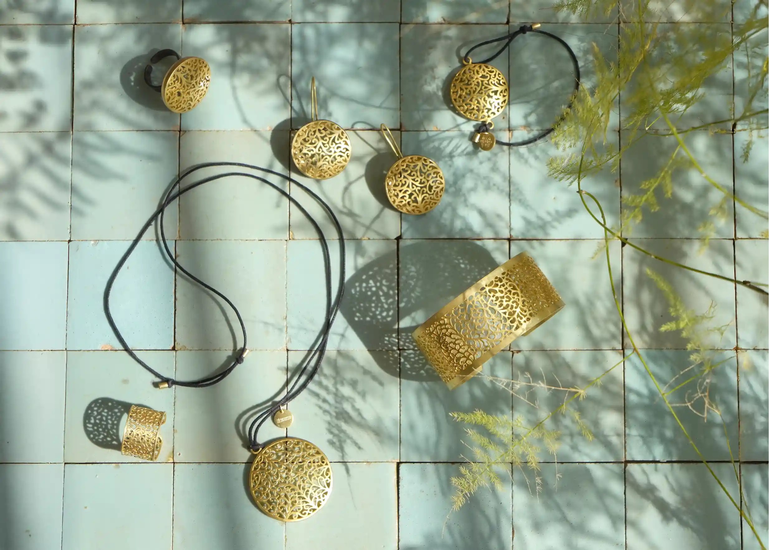 Photo prise de haut de l'ensemble de bijoux en laiton  de la gamme Jardin secret : manchette, bague, bracelet