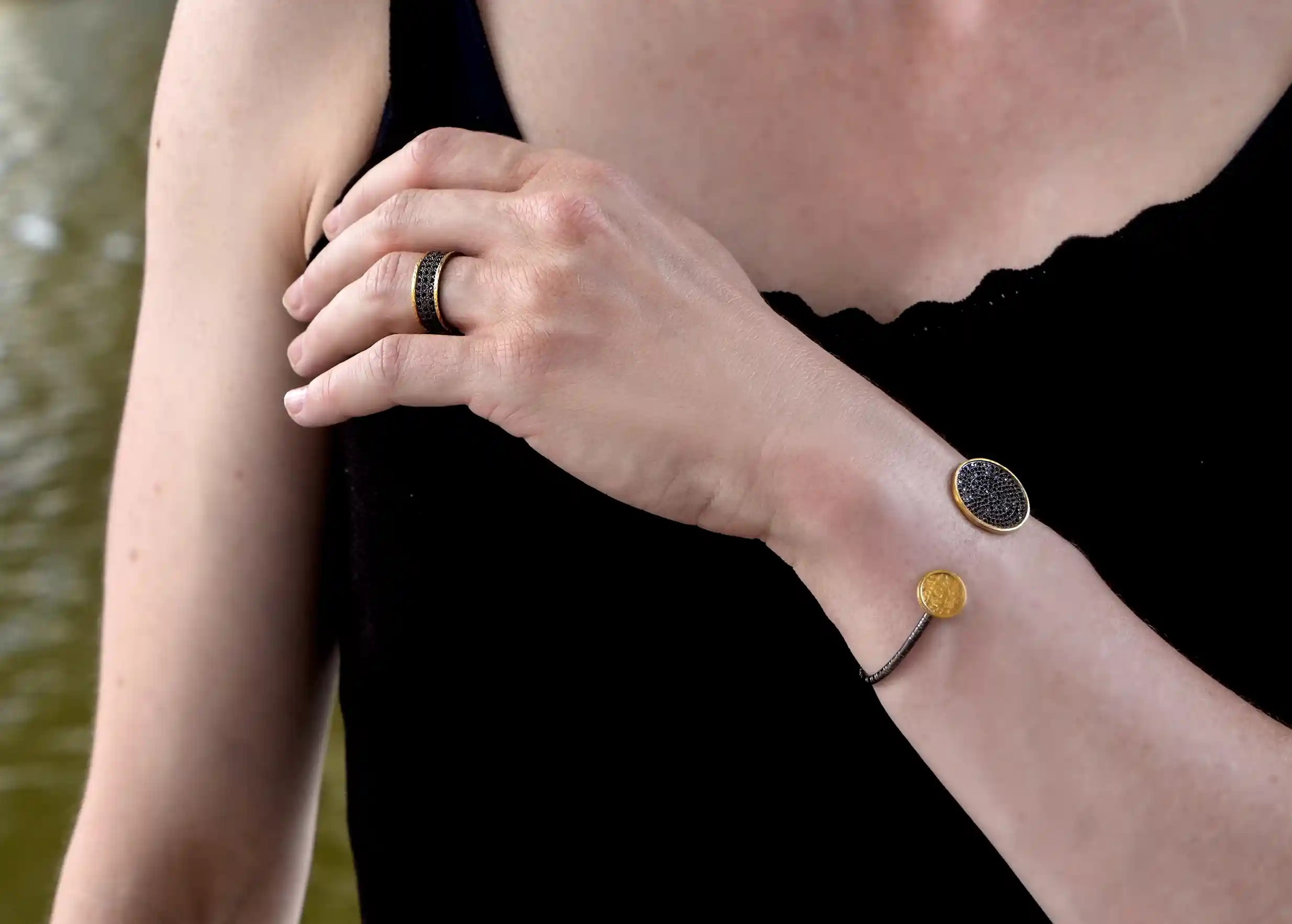Woman wearing an adjustable brass and zirconium ring, Dawn of Time collection