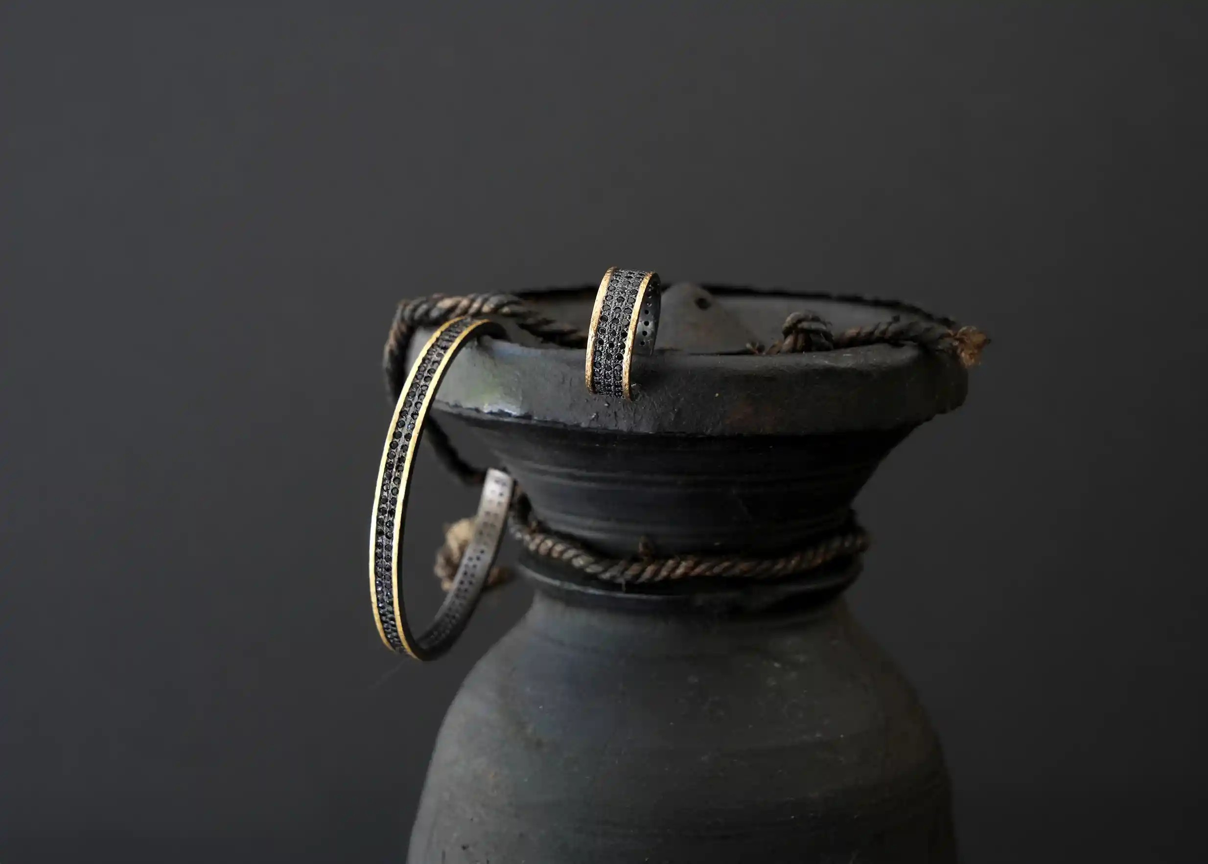 Set of brass rings and bands with a gold effect, decorated with a band of black zirconium, Dawn of Time collection