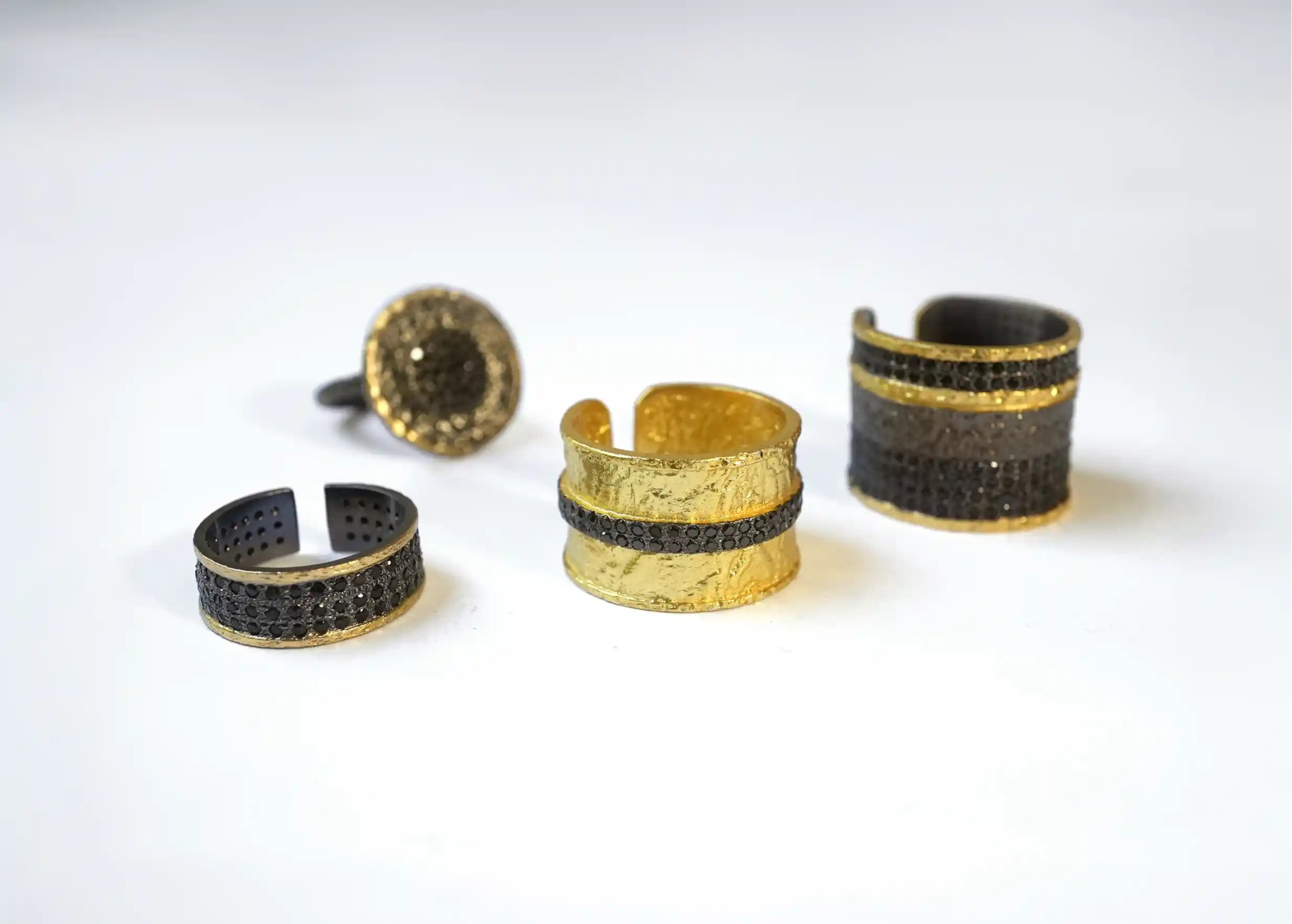 Anneaux et bagues en laiton de la collection Nuit des Temps par Karawan, sur fond blanc