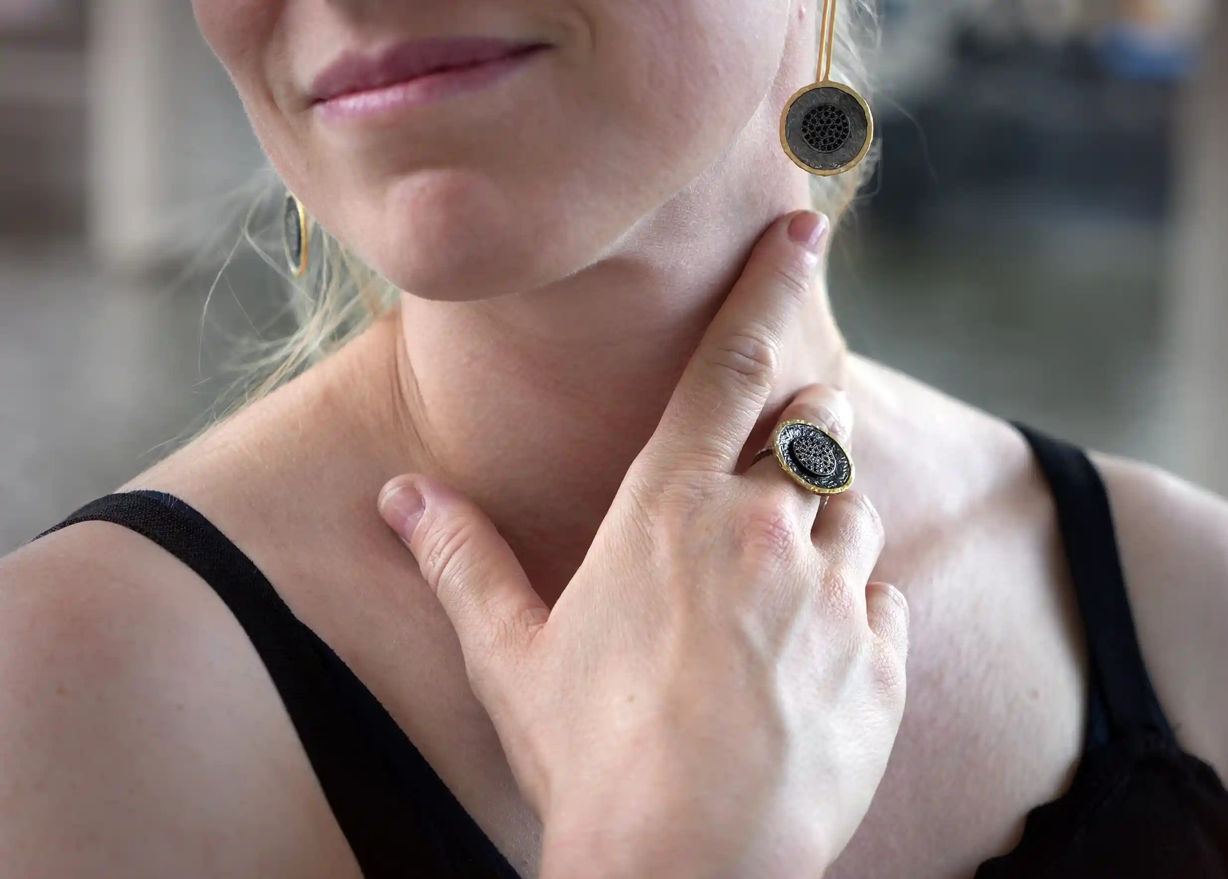 Smiling woman wearing a brass ring from the Nuit des Temps collection