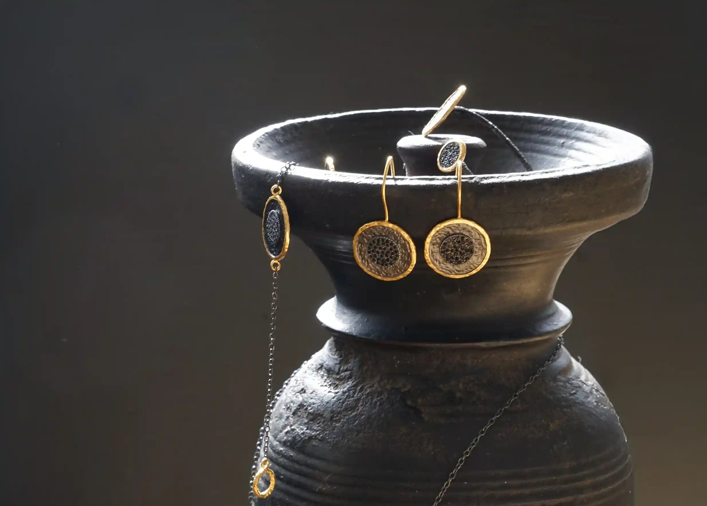 Ensemble d'anneaux et bagues de la collection Nuit des Temps en laiton à l'effet doré, ornés d'une bande de zirconium noir