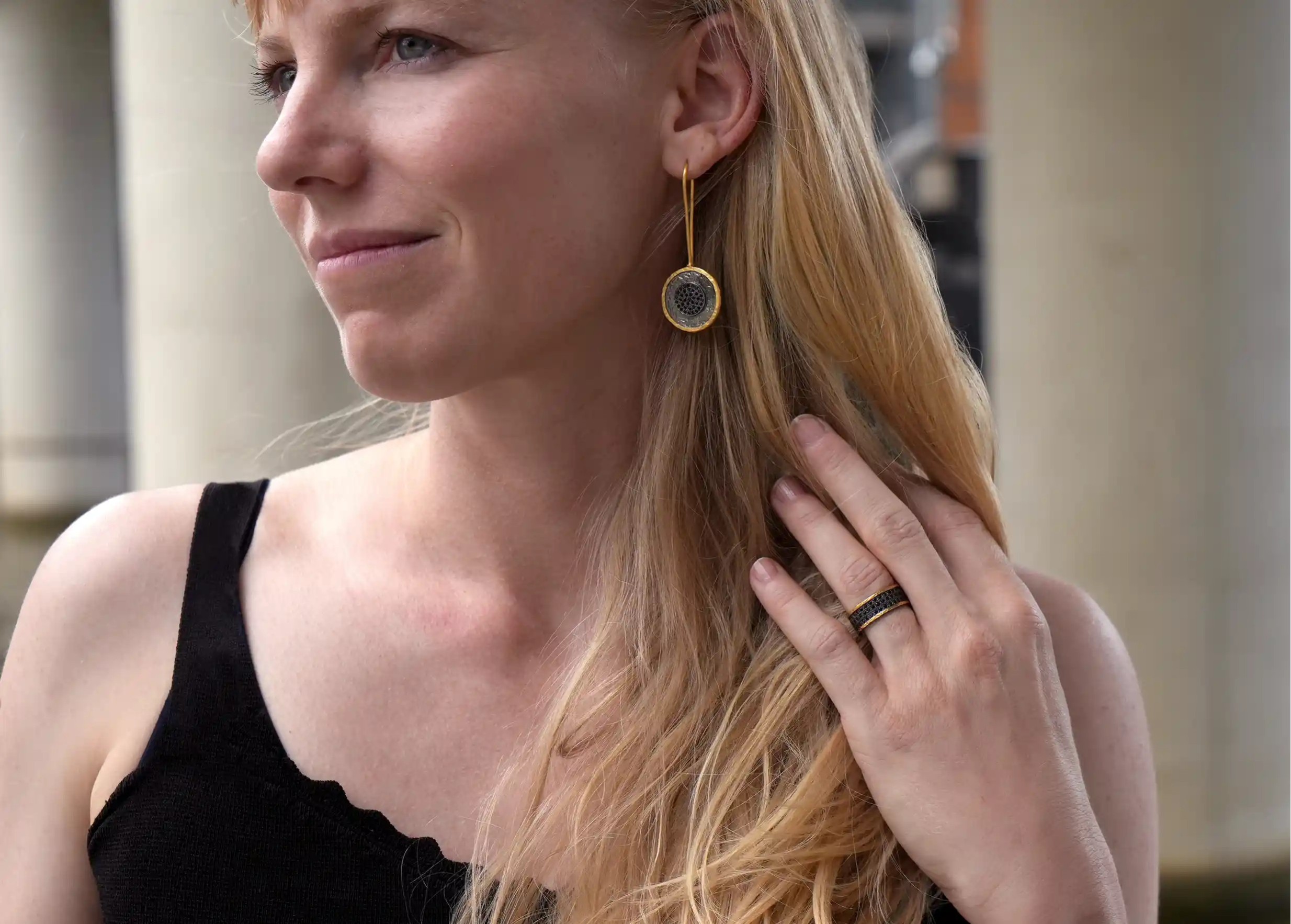 Boucle d'oreille en laiton et zirconium de la collection Nuit des Temps portée à l'oreille d'une femme