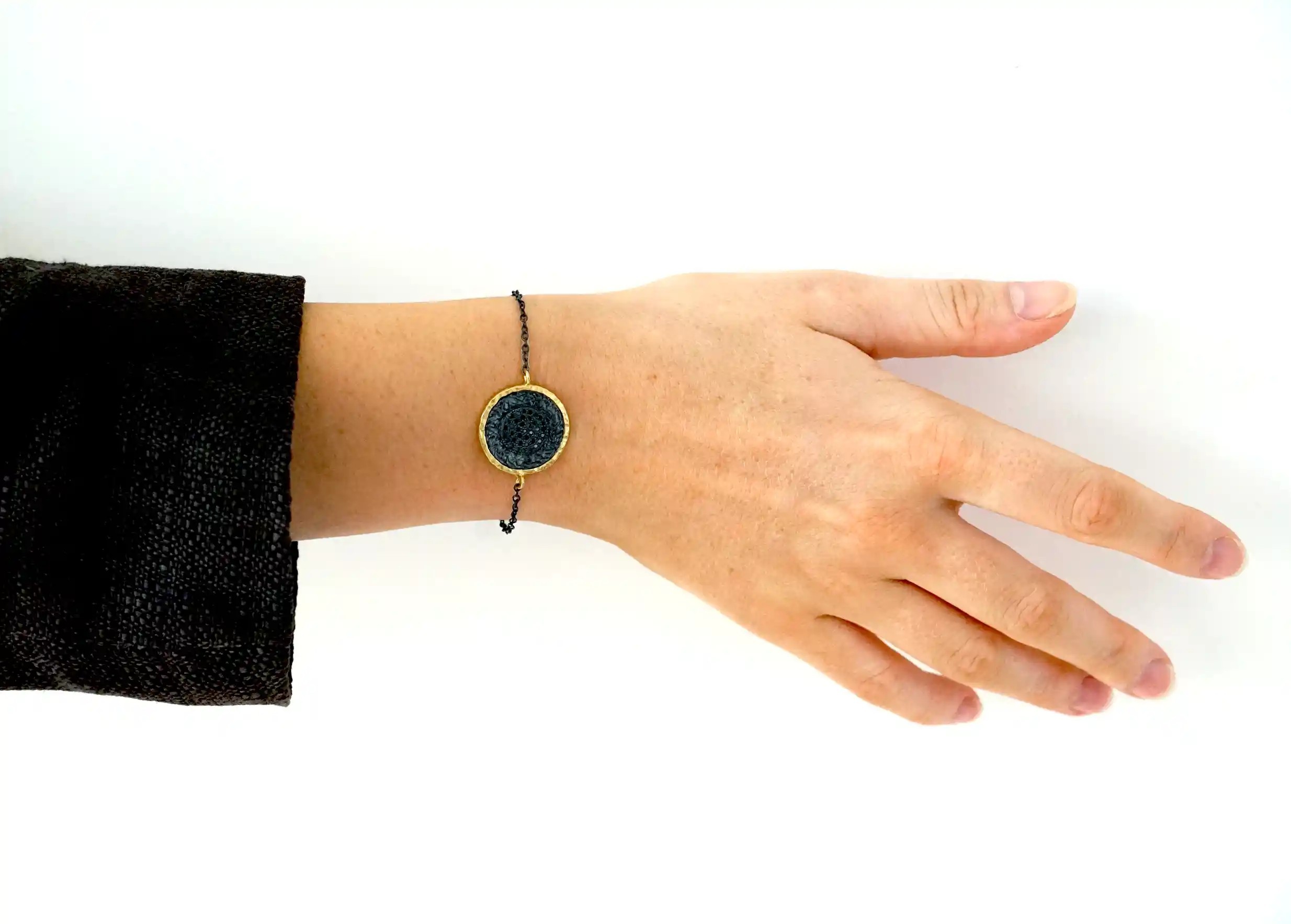 Brass bracelet from the Nuit des Temps collection worn around the wrist